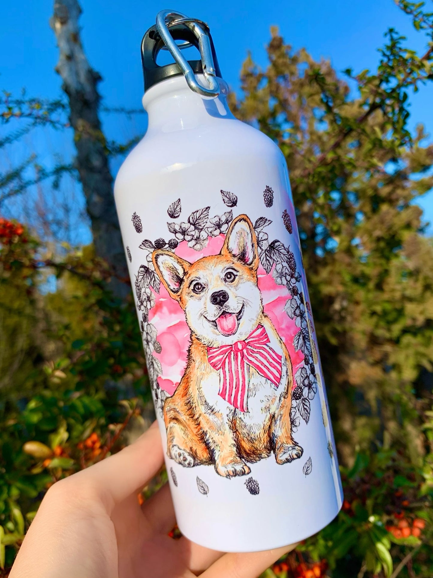 Fém kulacs vidám, világosbarna-fehér Corgi teljes alakos illusztrációval, rózsaszín virágmintával és apró gyümölcsös háttérrel.