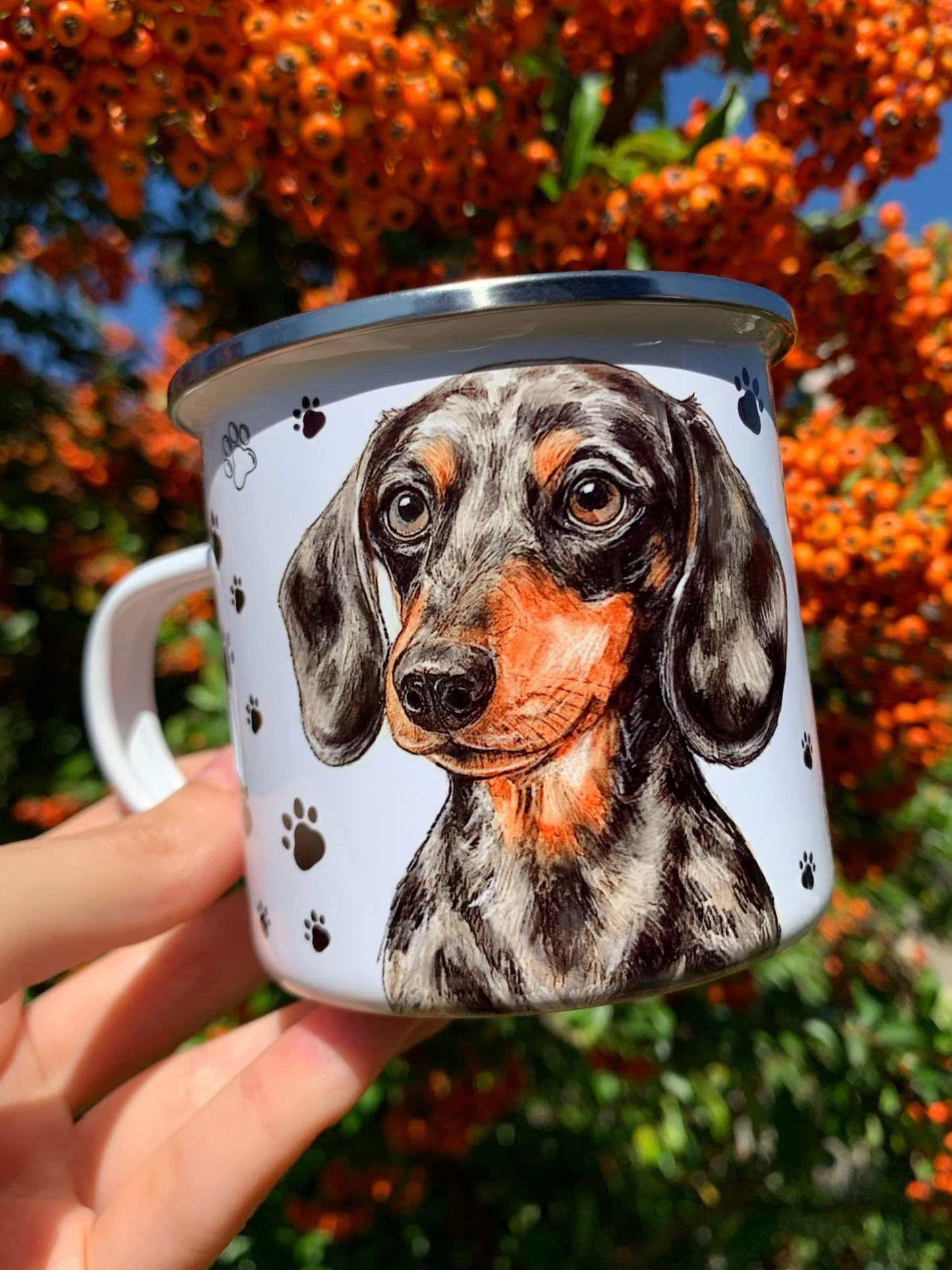 Kézzel festett merle tacskó mintás fém bögre, fehér alapon, fekete mancsnyom mintával, kétoldalas tacskó portréval. Prémium kézműves ajándék kutyás gazdiknak és tacskórajongóknak.