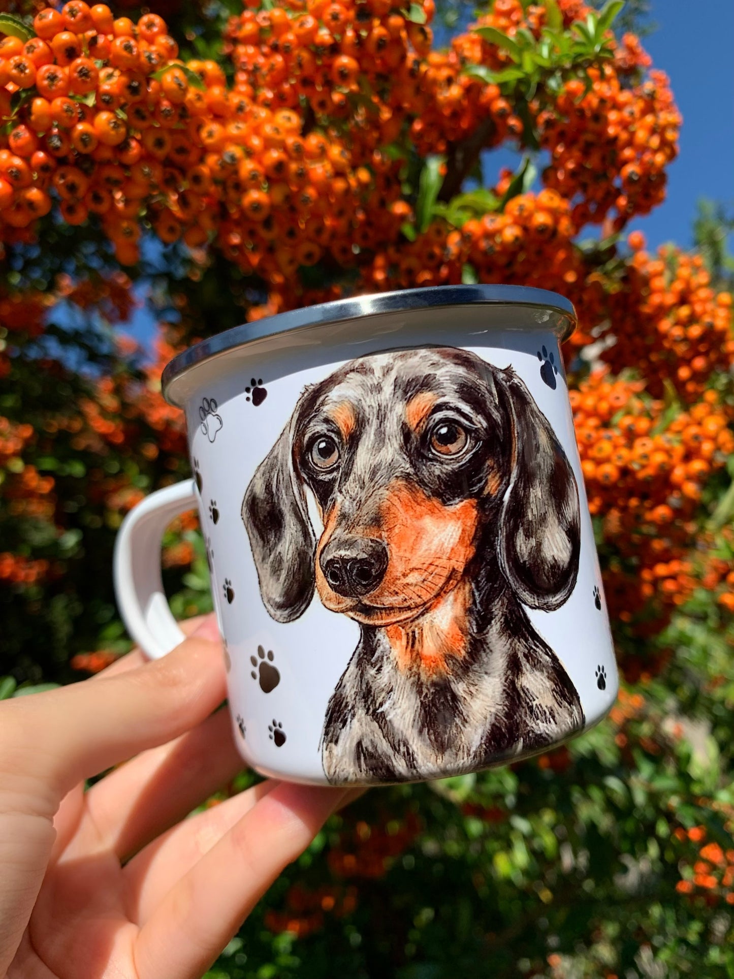 Kézzel festett tacskós ajándékbögre, merle mintás tacskó portréval és fekete mancsos grafikával, fehér alapon. A legjobb választás, ha egyedi, kézműves kutyás ajándékot keresel.