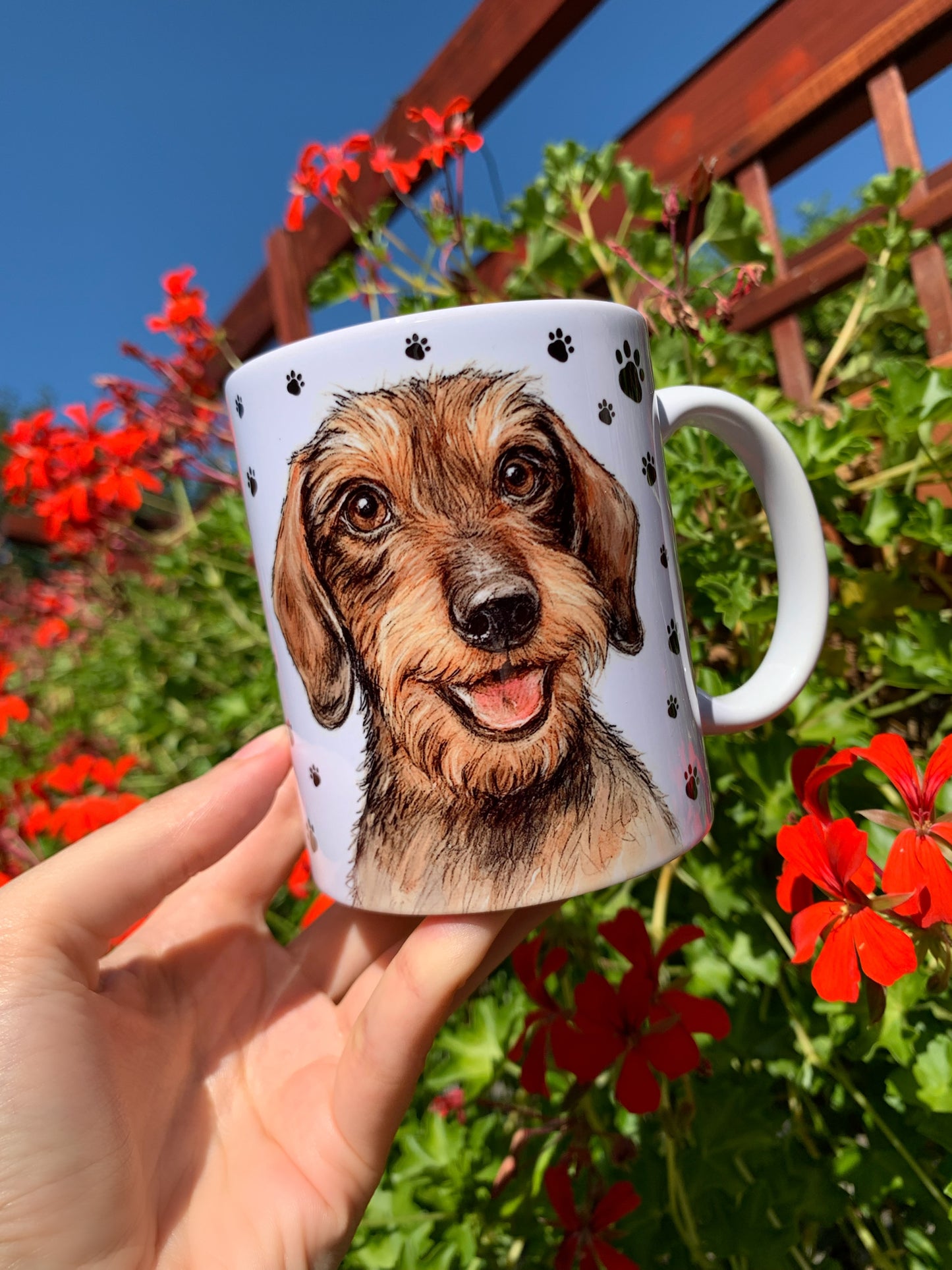 Részletgazdag tacskó mintás bögre, szálkásszőrű kutya portréval és mancs mintás háttérrel, ideális tacskós ajándék gazdiknak és kutyabarátoknak.