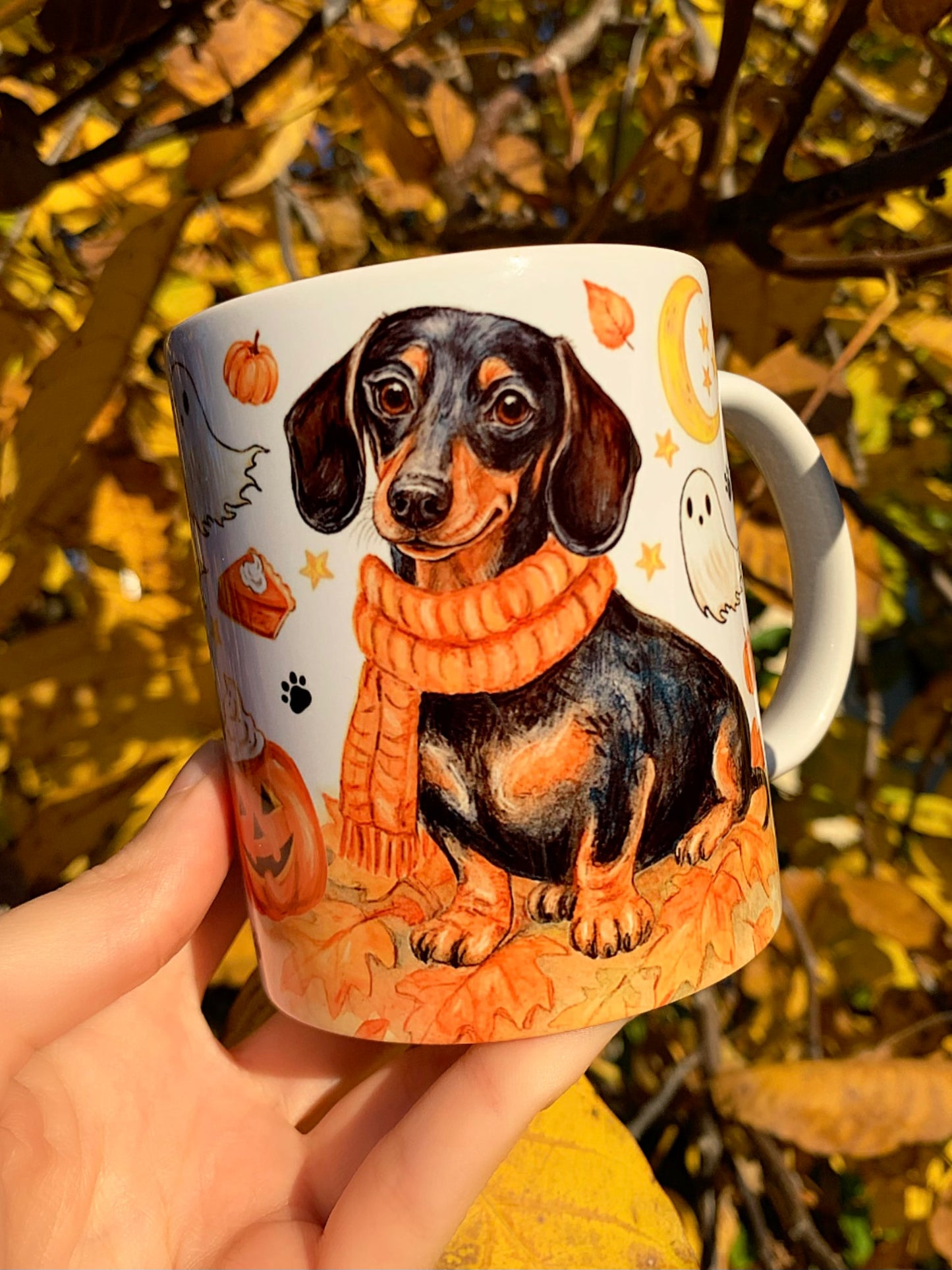 Kézzel festett, őszi tacskós bögre, amelyen barátságos cser tacskó, sütőtökök, szellemek és levelek díszítik a bögrét. 🍂🎃 A legszebb kézműves kutyás ajándék kávézós őszi napokra.