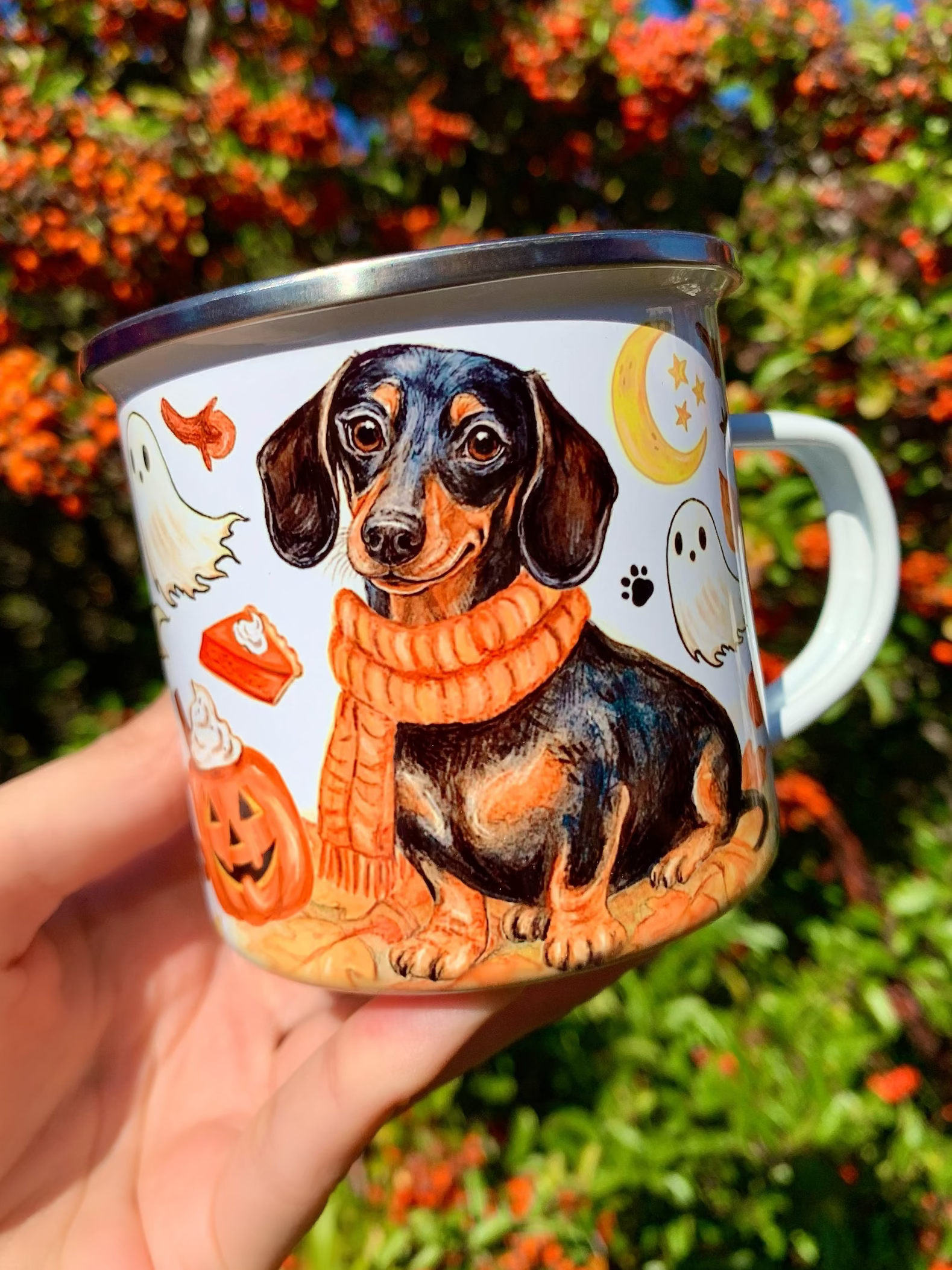 Meleg színekkel festett, kézzel rajzolt Halloweeni tacskós bögre, ahol a cser tacskó mellett sütőtökök, szellemek és kötött minták teremtenek kuckózós őszi hangulatot. Kutyás ajándék szeretteidnek! 🧡🐾