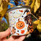 Fém bögre tacskó halloweeni pumpkin mintával, meleg narancs akvarell árnyalatokkal. Szellemes és boszorkányos részletek díszítik.