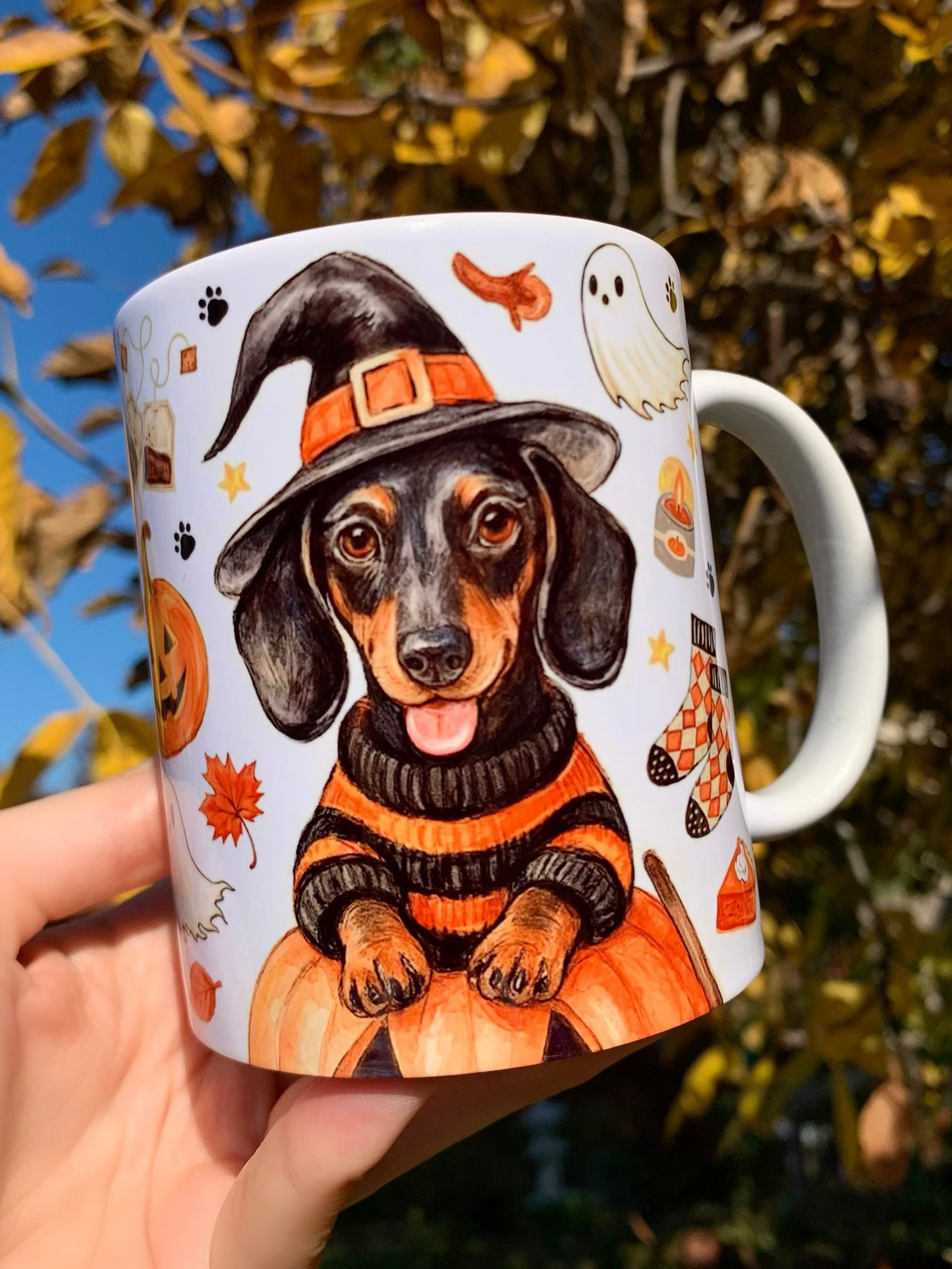 Egyedi tacskós ajándék halloweeni stílusban, kézzel festett cser tacskó mintával és őszi tökös, szellemes, fahéjas csigás illusztrációkkal díszített kerámia bögrén.