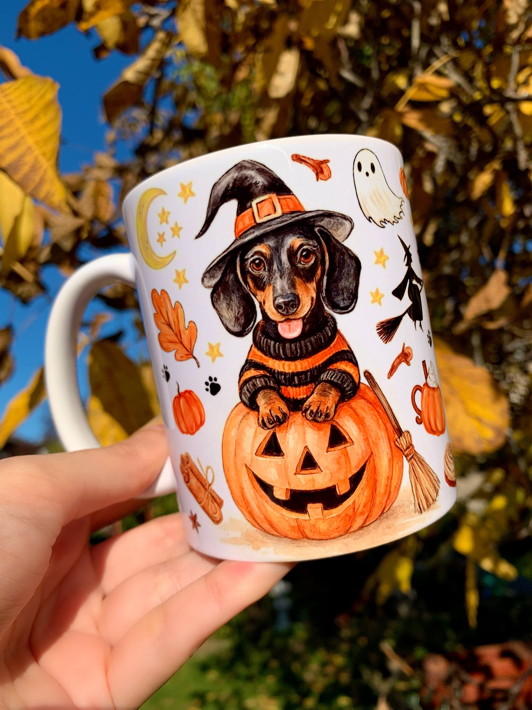 Prémium minőségű kézműves haloweeni tacskós kerámia bögre, cser tacskó boszorkány jelmezben, szellemekkel, pumpkin pie és latte mintákkal, egyedi iparművészeti dizájnnal.