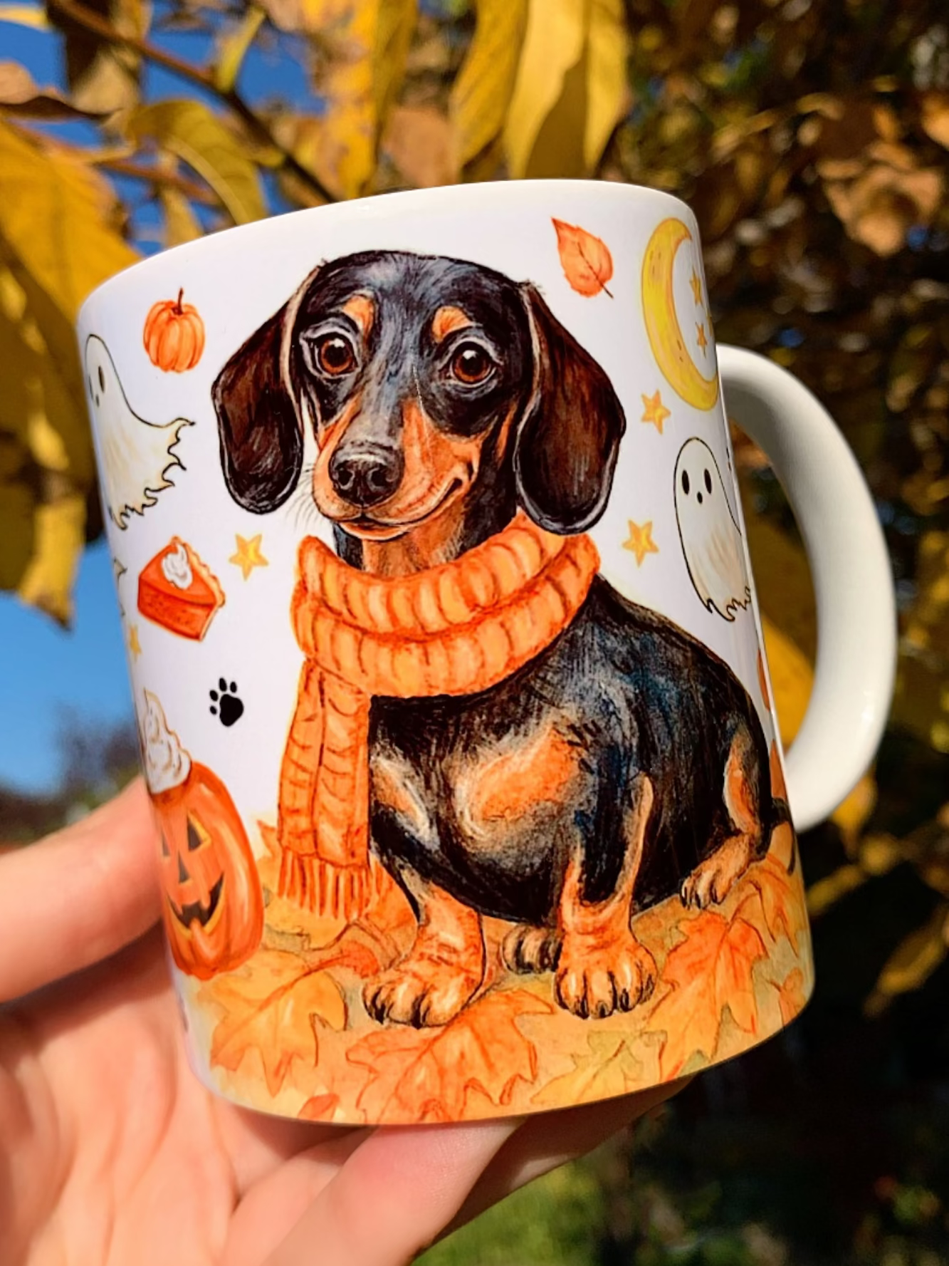 Halloweeni tacskós bögre kézzel festett, részletgazdag cser tacskó mintával, sütőtökökkel, szellemekkel és őszi levelekkel díszítve. 🎃 Prémium minőségű, egyedi kézműves ajándék kutyás gazdiknak és tacskórajongóknak. ☕🐶