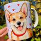 Kézzel festett Corgi kutyás bögre, amelyen Pusztai Juci iparművész egyedi, akvarellhatású illusztrációja látható. A mosolygó világosbarna-fehér Corgi mellett apró piros szívecskék díszítik a bögrét, romantikus, szeretetteljes hangulatot teremtve – tökéletes kézműves ajándék Corgi gazdiknak és kutyabarátoknak. ❤️☕🐶