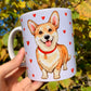 Corgi bögre kézzel festett mintával, amelyet a szerethető, játékos és barátságos Corgi kutyák inspiráltak. A pirosas szív minták és a finoman árnyalt ecsetvonások prémium, iparművészeti minőséget tükröznek. Ideális ajándék kutyás szeretteidnek!