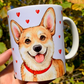 Corgi kutyás ajándékbögre, amely meleg tónusú, kézzel festett illusztrációkkal díszített. A mosolygó Corgi portré és az apró piros szívek a szeretet és vidámság üzenetét hordozzák – tökéletes ajándék minden Corgi rajongónak. ❤️