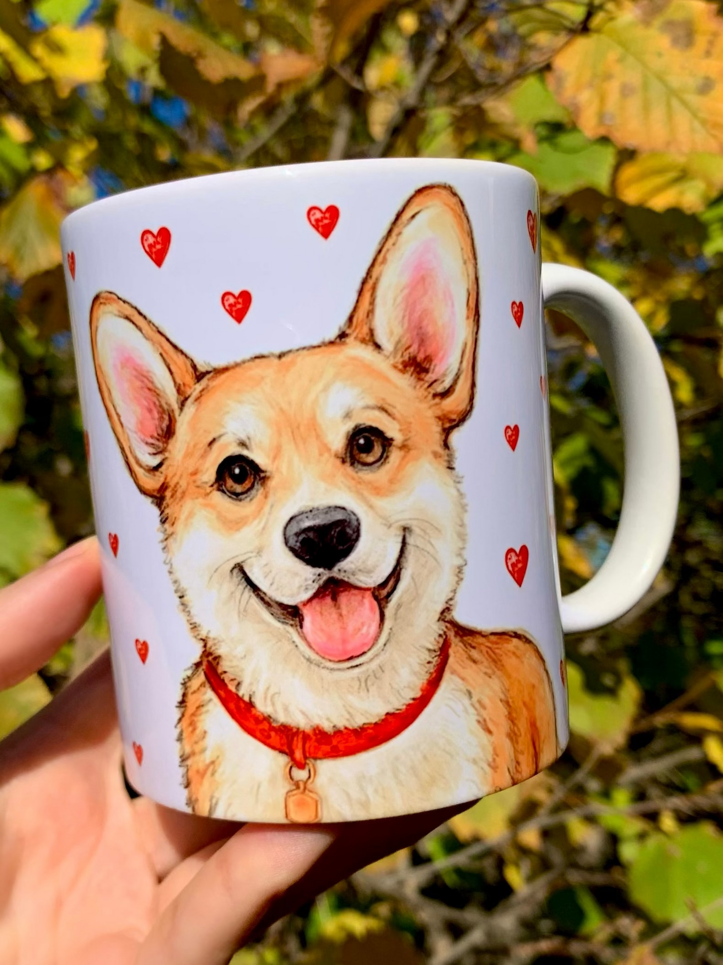 Corgi kutyás ajándékbögre, amely meleg tónusú, kézzel festett illusztrációkkal díszített. A mosolygó Corgi portré és az apró piros szívek a szeretet és vidámság üzenetét hordozzák – tökéletes ajándék minden Corgi rajongónak. ❤️