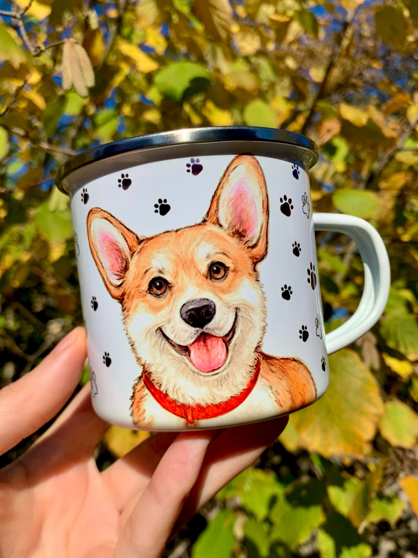 Kézműves Corgi kutyás bögre, amely akvarellfestékkel megrajzolt, mosolygó Corgit ábrázol. A piros nyakörves kutyus részletgazdagan kidolgozott, a háttér mintázata választható – szívecskés vagy mancsos. Ideális ajándék Corgi gazdiknak és kutyabarát kávérajongóknak.