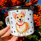 Corgi kutyás fém bögre – kézzel festett, kézműves kutyás ajándék Pusztai Juci iparművésztől. Az egyik oldalon mosolygó, piros nyakörves Corgi portré, a másikon egész alakos illusztráció látható. A mancsos és szíves díszítés különleges, szeretetteljes részleteket ad a bögrének. ❤️🐶