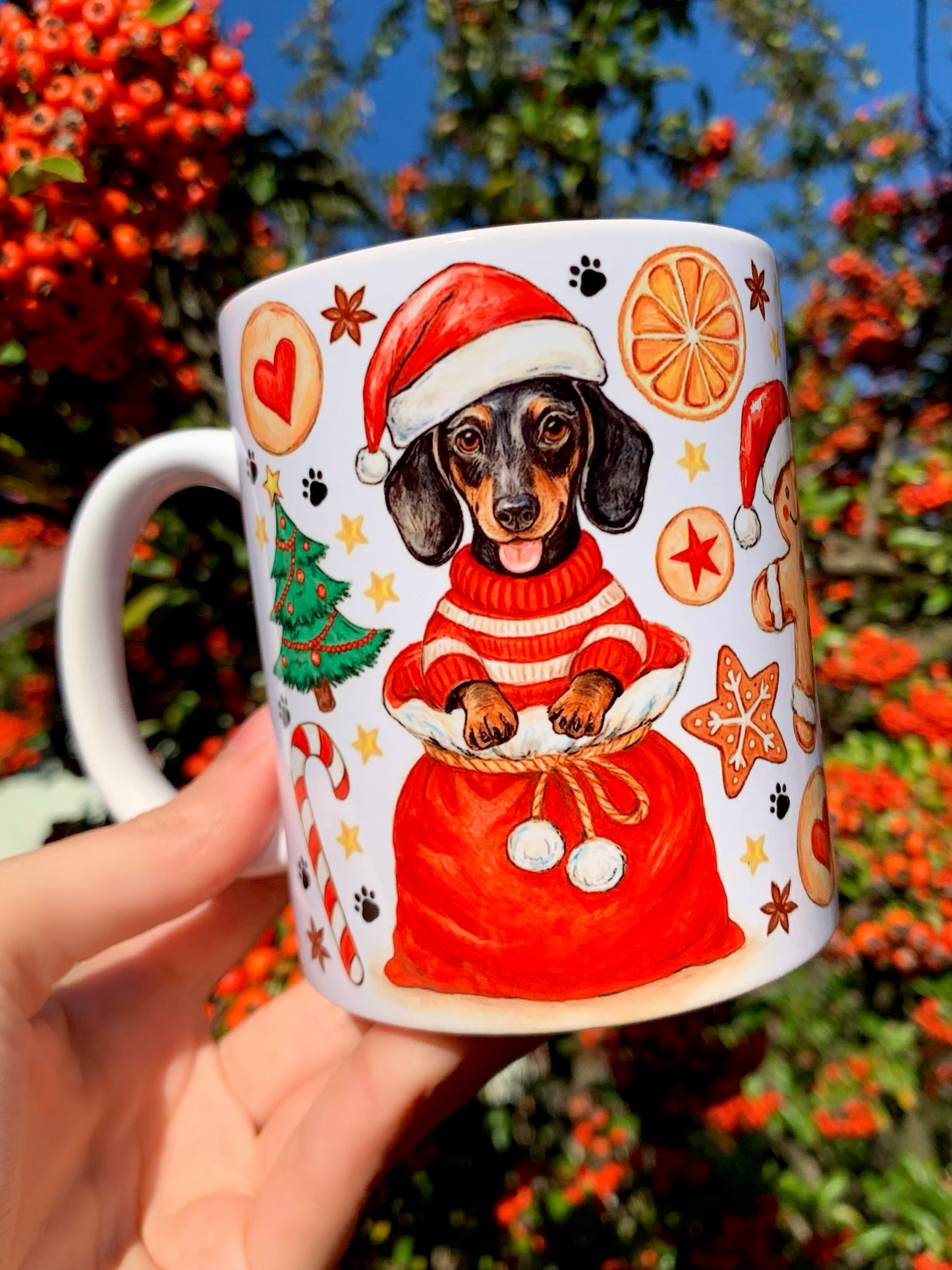 Tacskós karácsonyi kerámia bögre részletes ceruzavonalas és akvarell technikával készült mintával. A meleg tónusú kutyaportré ünnepi kiegészítőkkel és természetes akvarelltextúrával egészül ki. Stílusos, elegáns, ajándékozható darab.