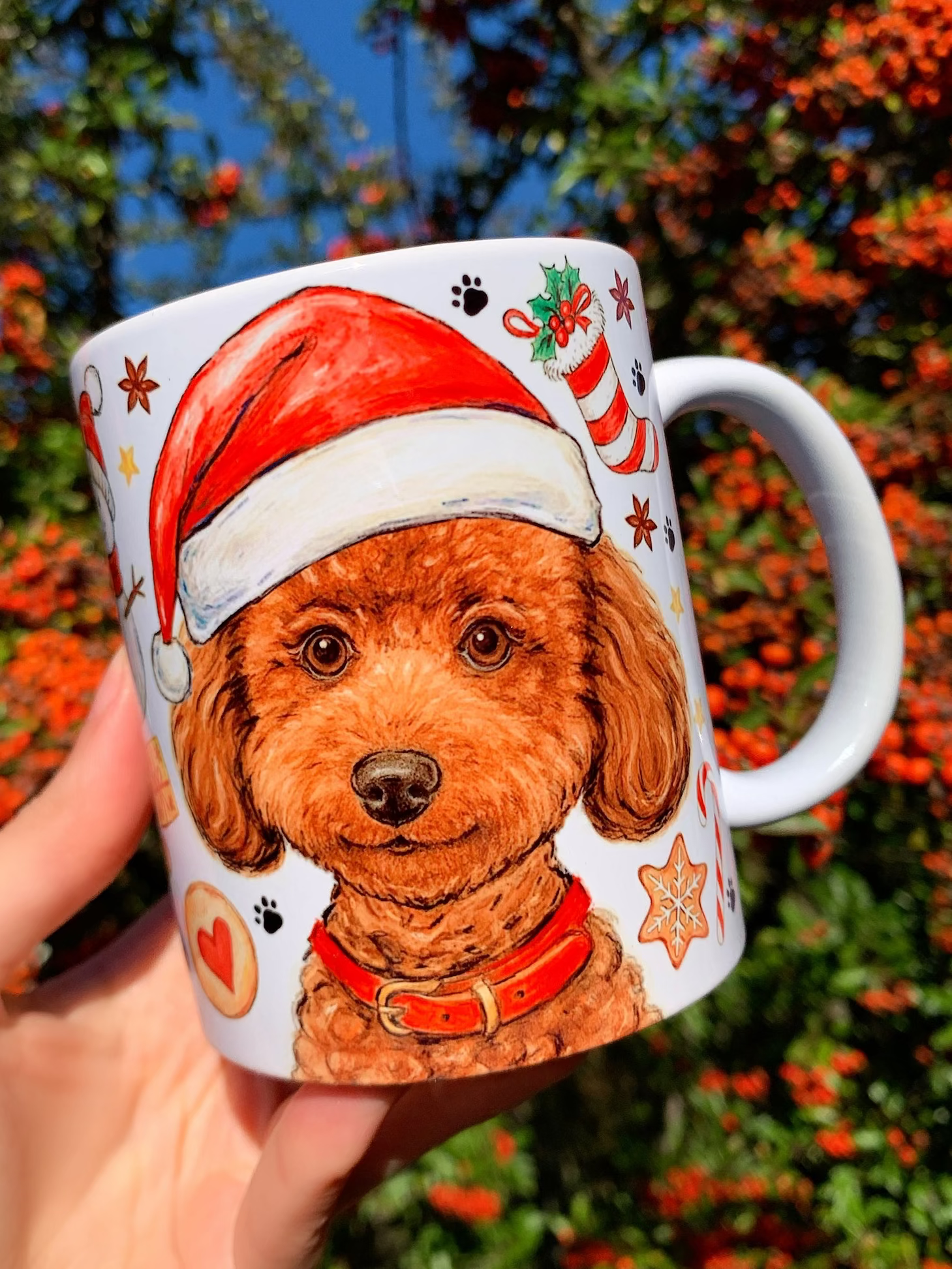 Festett karácsonyi Toy Poodle bögre barna, göndör szőrű uszkárral és kézzel rajzolt karácsonyi édesség mintákkal. Mézeskalács figurák, cukorpálcák és fenyődíszek keretezik a mosolygó uszkár grafikát. Kézműves magyar kutyás ajándék teázáshoz.