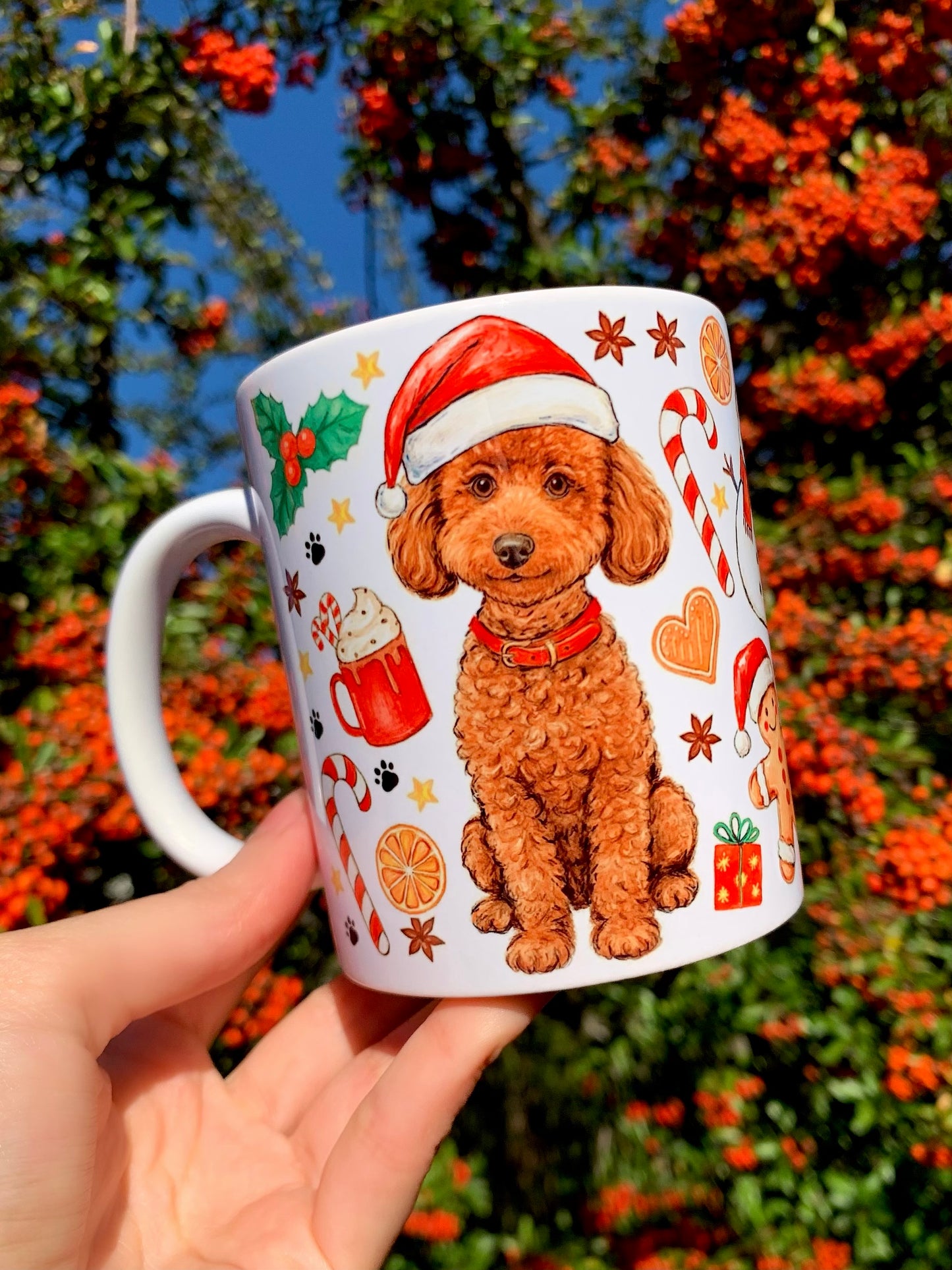 Prémium kerámia bögre kézzel rajzolt és festett Toy Poodle illusztrációval – Mikulássapkás, mosolygó, göndör szőrű uszkár portréval és egész alakos karácsonyi kutyás grafikával. Kézműves magyar termék kutyabarátoknak és ünnepi uszkár ajándéknak.