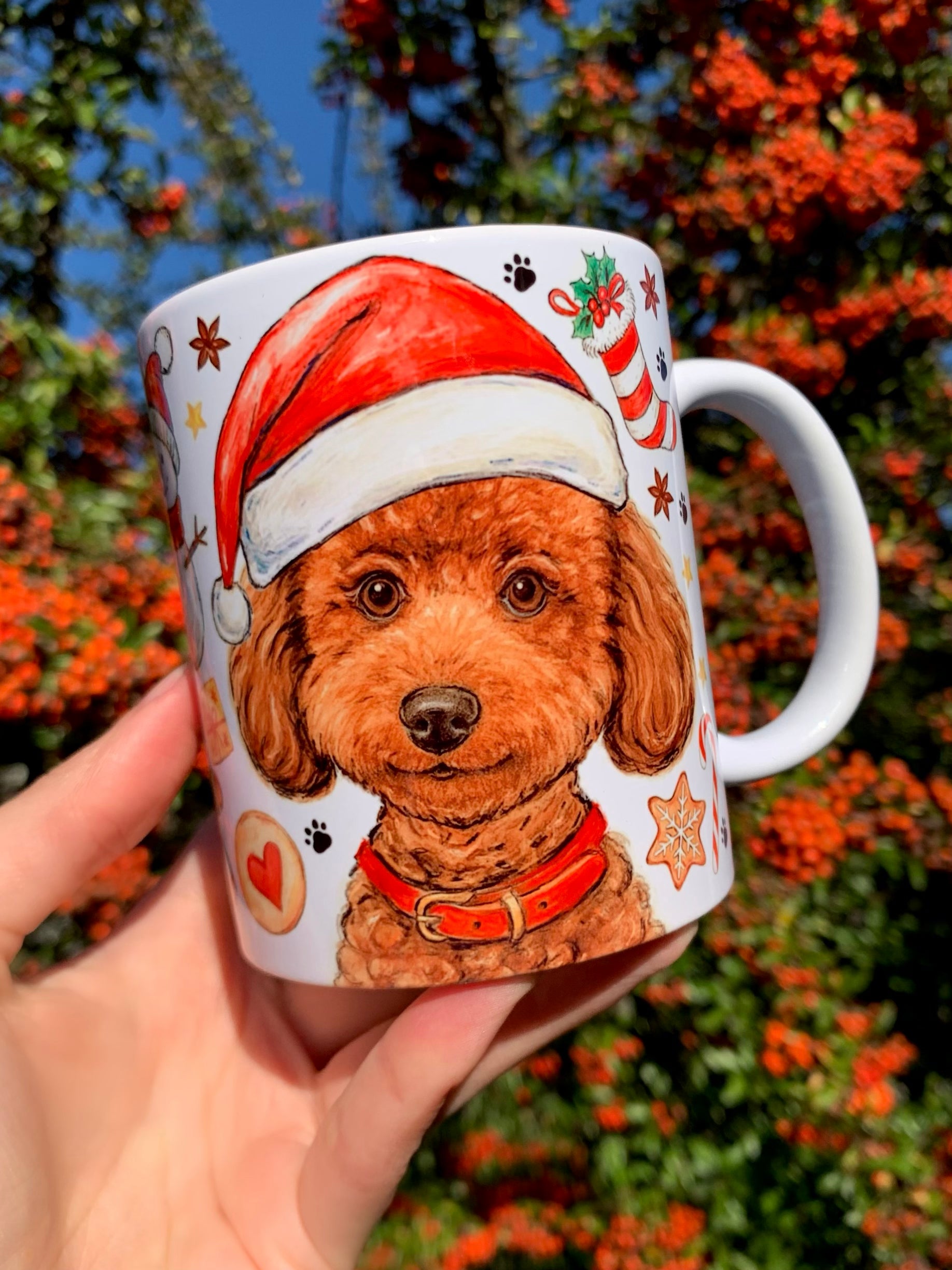 Barna Toy Poodle kutyás karácsonyi kerámia bögre részletgazdag, kézzel rajzolt akvarellmotívumokkal. A Mikulássapkás uszkár portréja élethű, meleg tónusú és szerethető. Kézműves magyar kutyás ajándék karácsonyra.