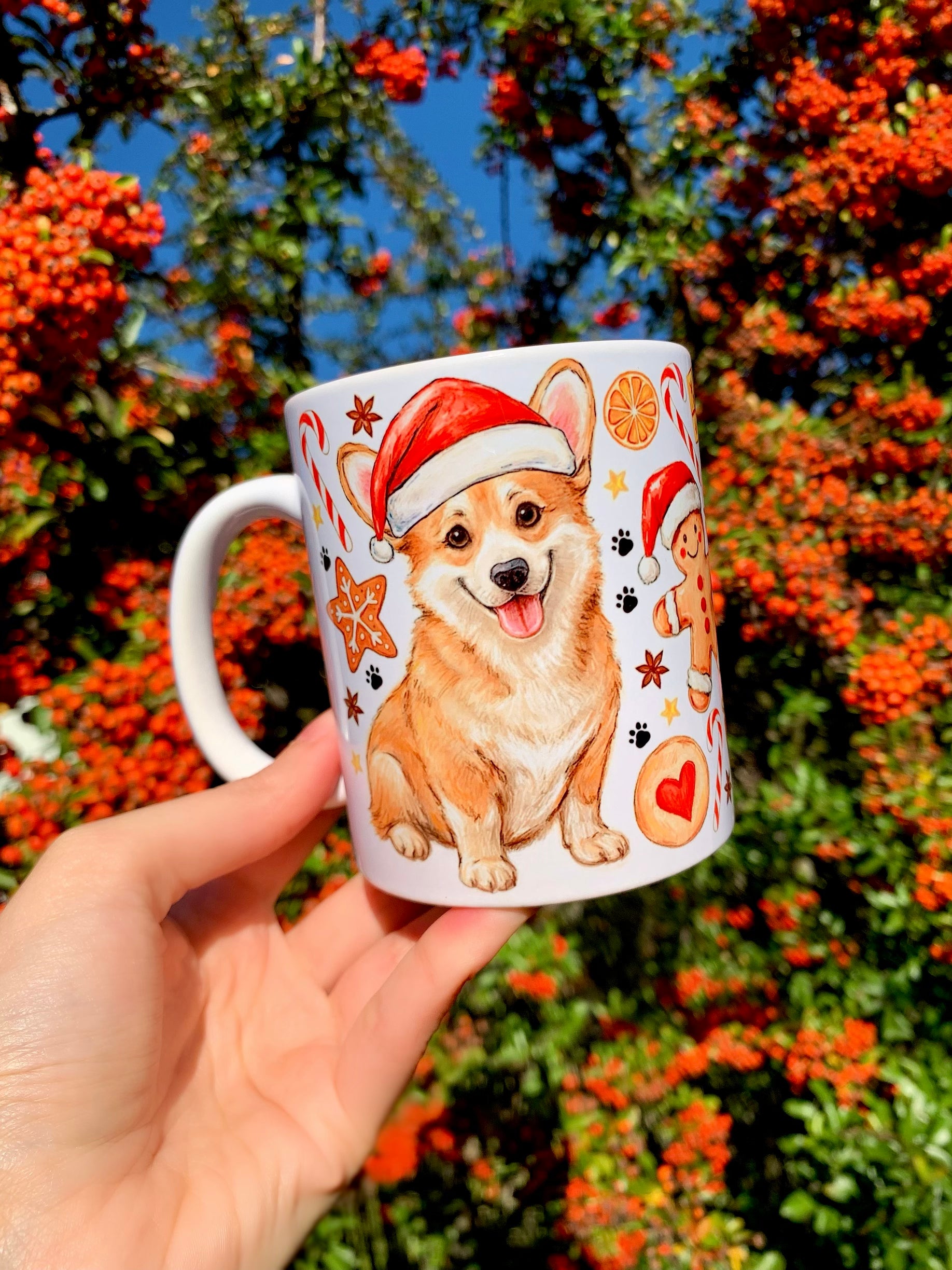 Kézzel rajzolt Corgi kutyás bögre, ünnepi piros-zöld karácsonyi díszítéssel és szerethető, mosolygó Corgi portréval – egyedi karácsonyi ajándék ötlet.