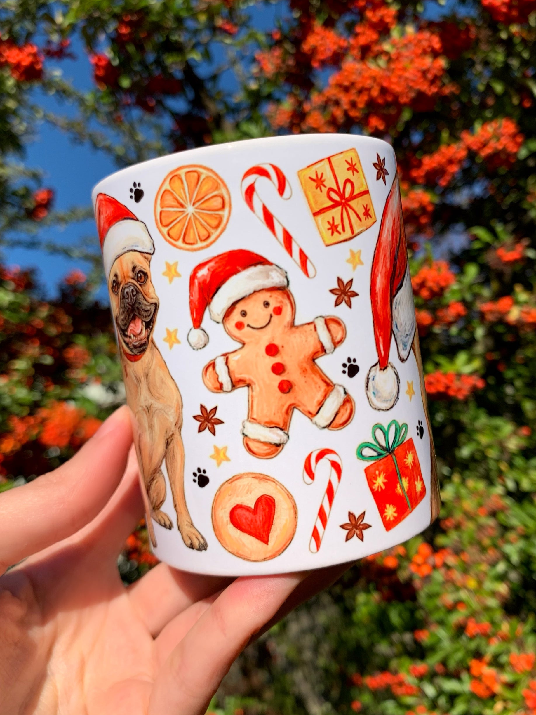 Bájos francia bulldog karácsonyi kutyás bögre Pusztai Juci kézzel festett illusztrációjával; mézeskalács figurák, harangok és fenyőágak díszítik. Tökéletes ajándék bulldograjongóknak.