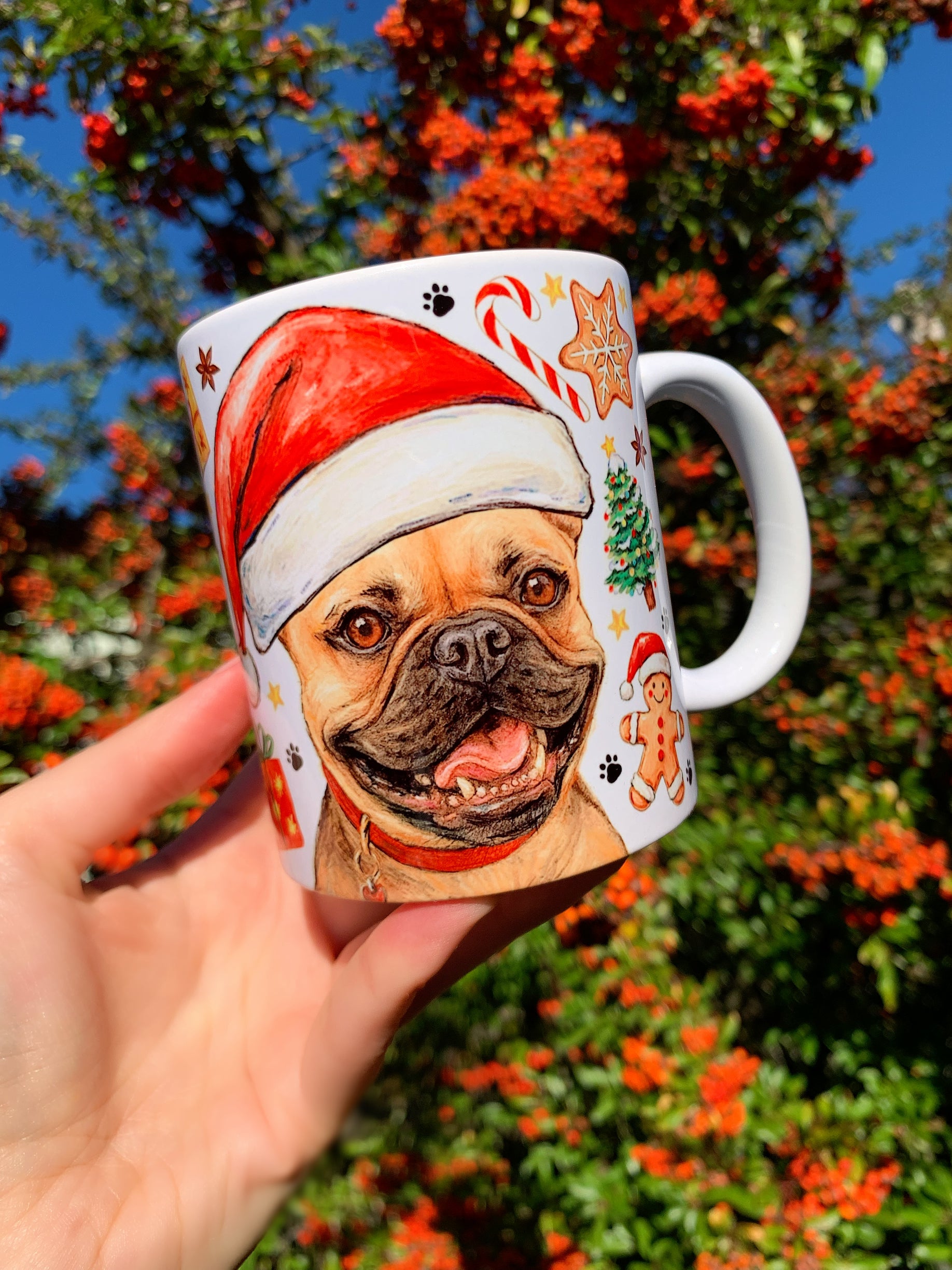 Nyomott orrú, bézs francia bulldog portréja díszíti ezt a karácsonyi kerámia bögrét, gazdagon festett cukorkák, mézeskalács figurák és ünnepi motívumok társaságában. Kézműves kutyás ajándék.