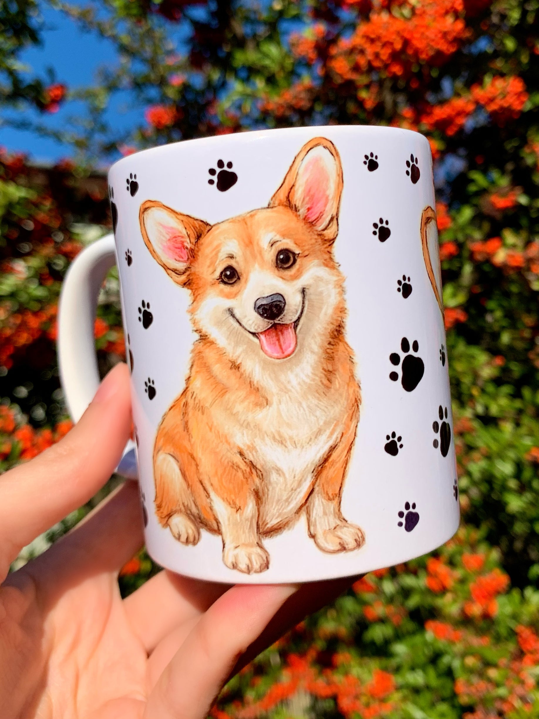 Mancsos mintás Corgi kerámia bögre, Pusztai Juci akvarelles grafikáival. A mosolygó, világosbarna Corgi kutya szerethető karaktere tökéletesen megjelenik a kézműves festésben.