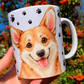 Kézzel festett Corgi kutyás kerámia bögre, Pusztai Juci részletgazdag illusztrációjával: mosolygó Corgi portré egyik oldalon, egész alakos kutyus a másikon, apró fekete mancs mintás háttérrel. Prémium kézműves kutyás ajándék gazdiknak.