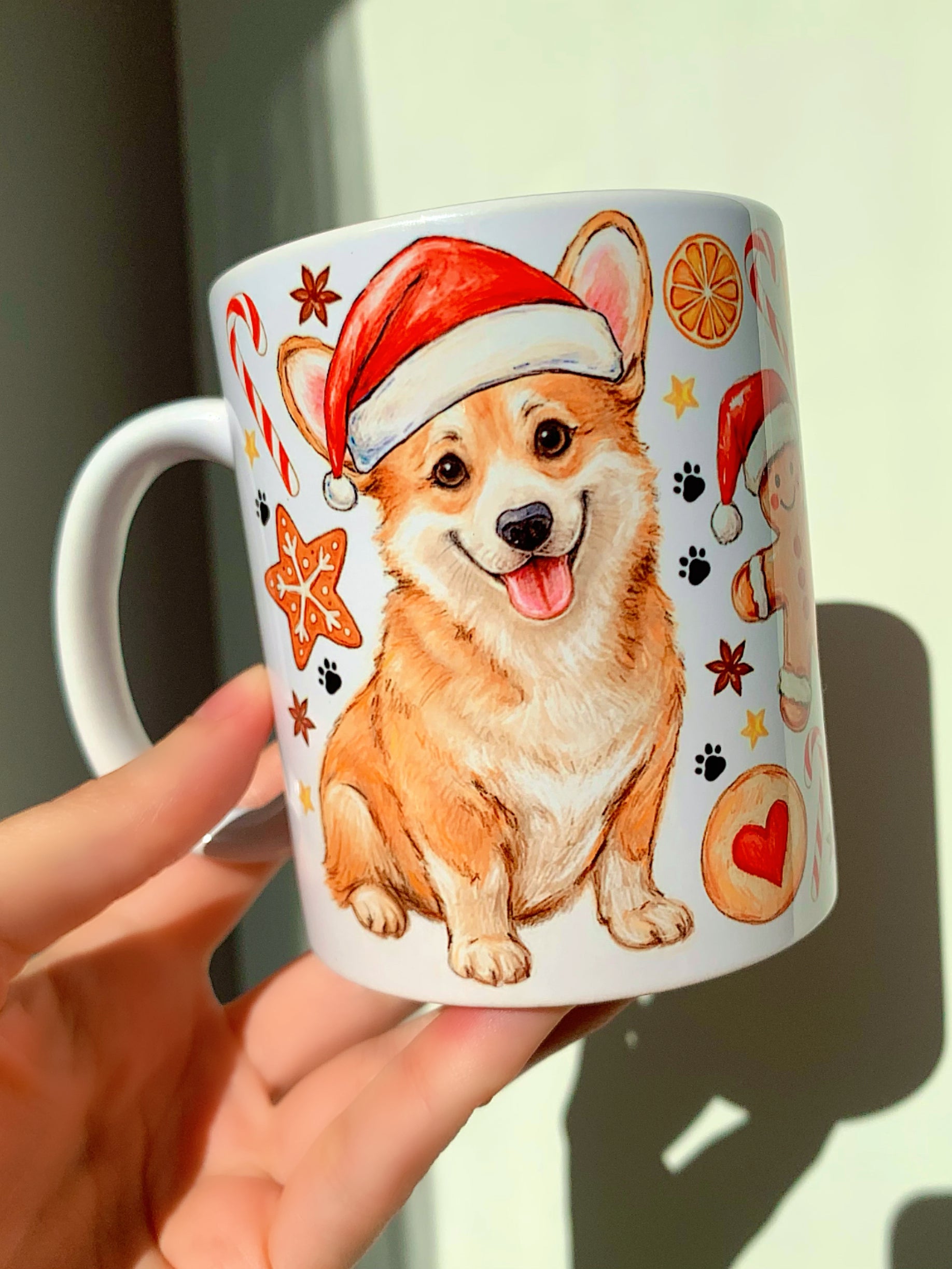 Corgi karácsonyi bögre, kézzel festett kutyás illusztrációval, mézeskalács sütemény és karácsonyi cukorka motívumokkal – ajándék Corgi imádóknak.