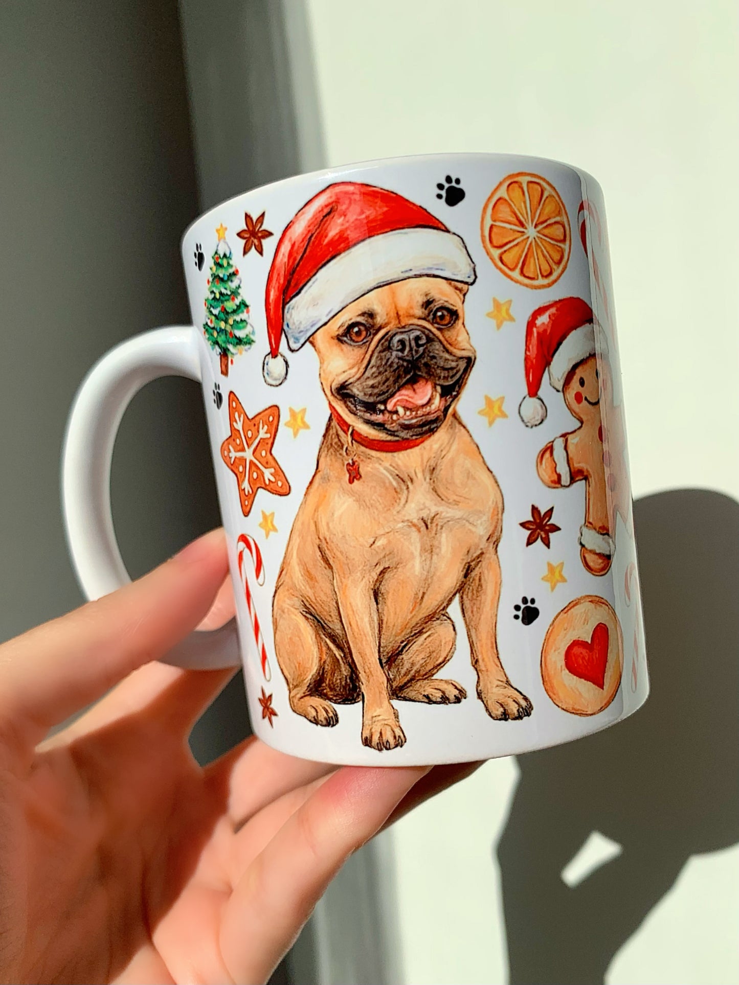 Kézzel festett francia bulldog kutyás bögre mikulássapkás, bézs színű bulldoggal és karácsonyi mézeskalács, cukorka és ünnepi díszek motívumaival. Prémium minőségű kerámia ajándék gazdiknak.