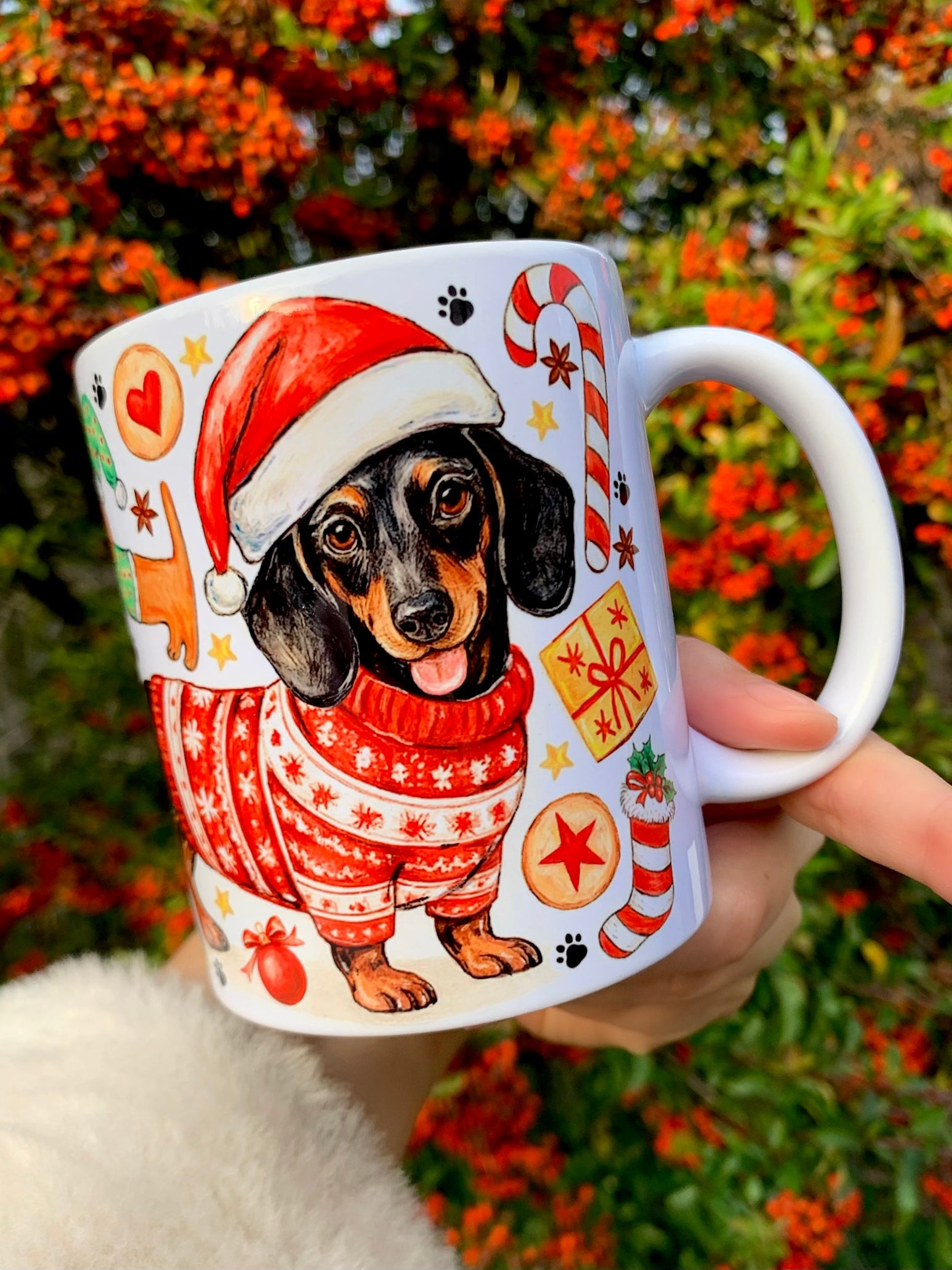 Karácsonyi tacskós bögre kézzel rajzolt illusztrációval. Ünnepi tacskók, mézeskalácsok és karácsonyi dekorációk jelennek meg a mintán. Különleges kutyás ajándék karácsonyra.