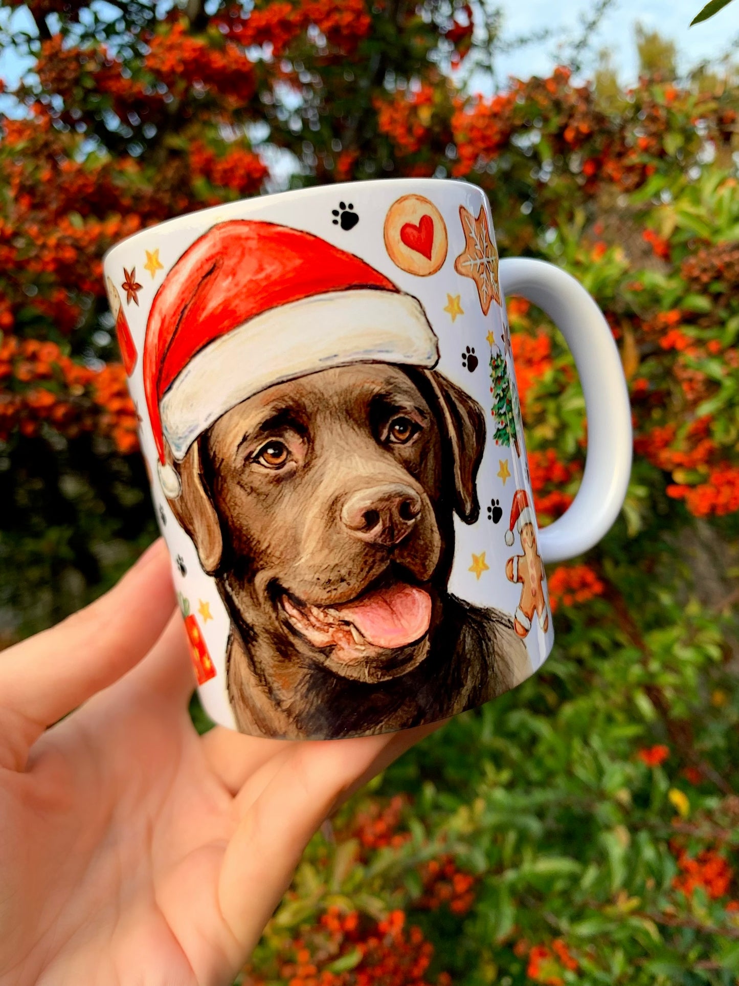 Labrador kutyás karácsonyi bögre prémium kerámiából. Barna labrador ünnepi pózban, körülötte karácsonyi dekorációk. Kézműves bögre karácsonyi ajándéknak.