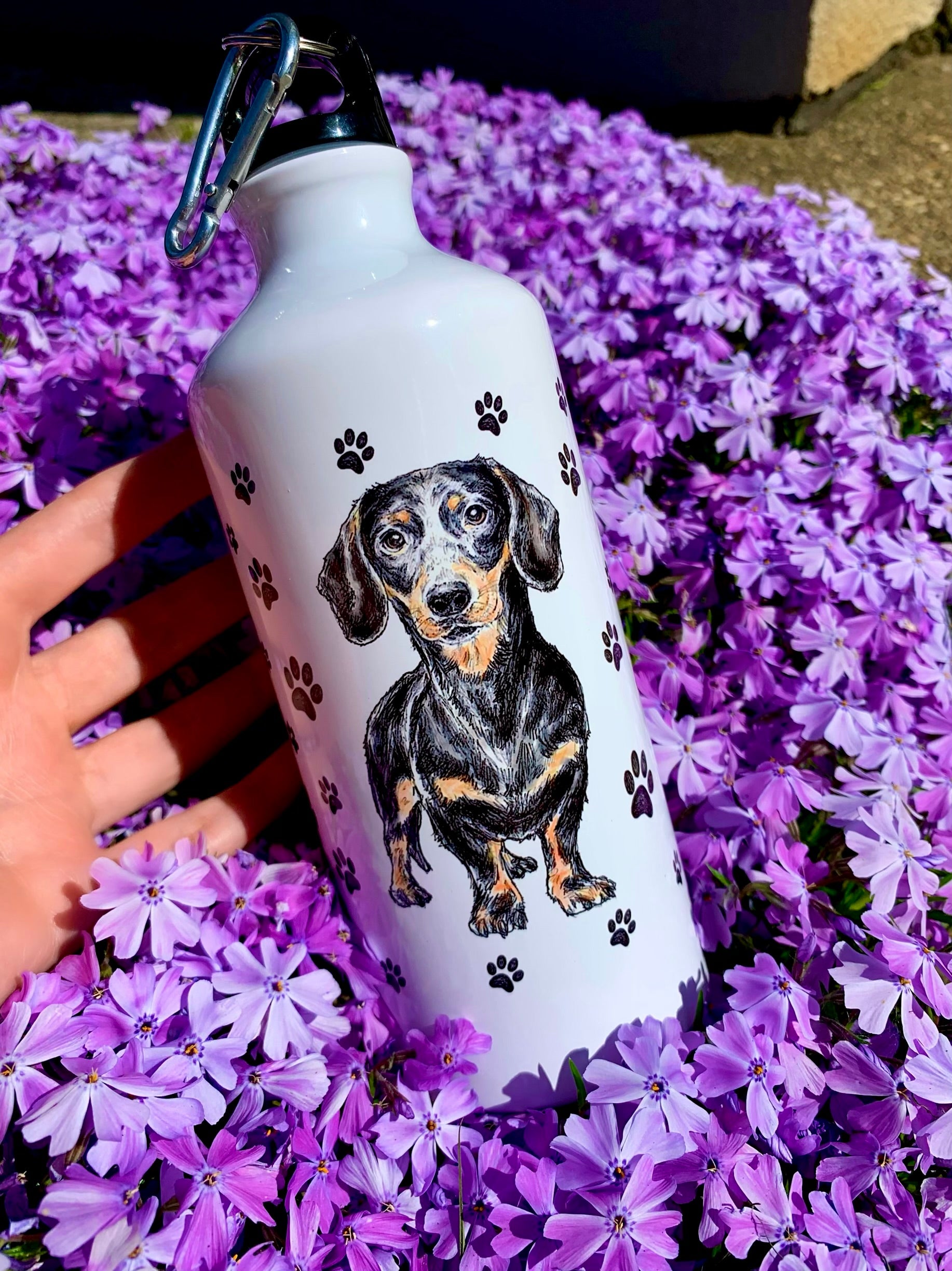 Ez az egyedi tacskós kulacs kézzel festett cser tacskó portréval és mancsos díszítéssel készült. A nagy űrtartalom miatt egész nap friss vizet biztosít, így ideális aktív gazdiknak. Művészi, magyar készítésű kutyás ajándék, amely minden tacsi-imádónak örömet szerez.