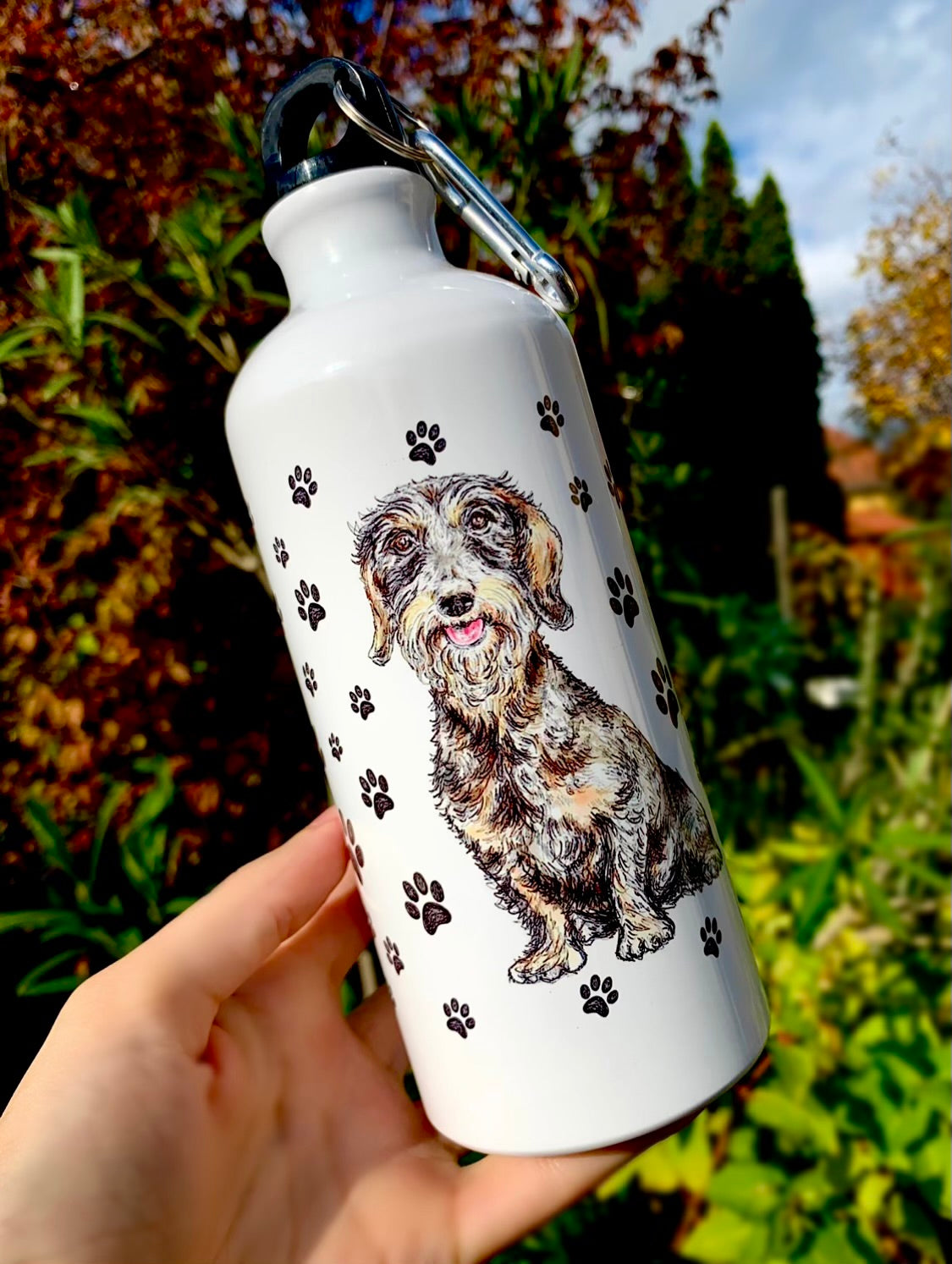 Ez a tacskós kulacs művészi, akvarelles szálkásszőrű tacskó mintával díszített, amely meleg és karakteres hangulatot kölcsönöz neki. A nagy űrtartalom egész nap kényelmes vízfogyasztást biztosít. Prémium ajándék kutyabarátoknak, akik tartós és igényes terméket keresnek.