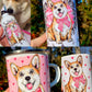 Corgi kutyás kollekció – kézzel festett mintás bögrék, kulacs és vászontáska világosbarna-fehér kutyával, virágos-gyümölcsös díszítéssel, fehér háttérrel.