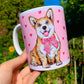 Kerámia bögre világosbarna-fehér Corgi kutyával, kézzel rajzolt és akvarellfestett részletekkel, rózsaszín szív mintákkal, fehér háttérrel.