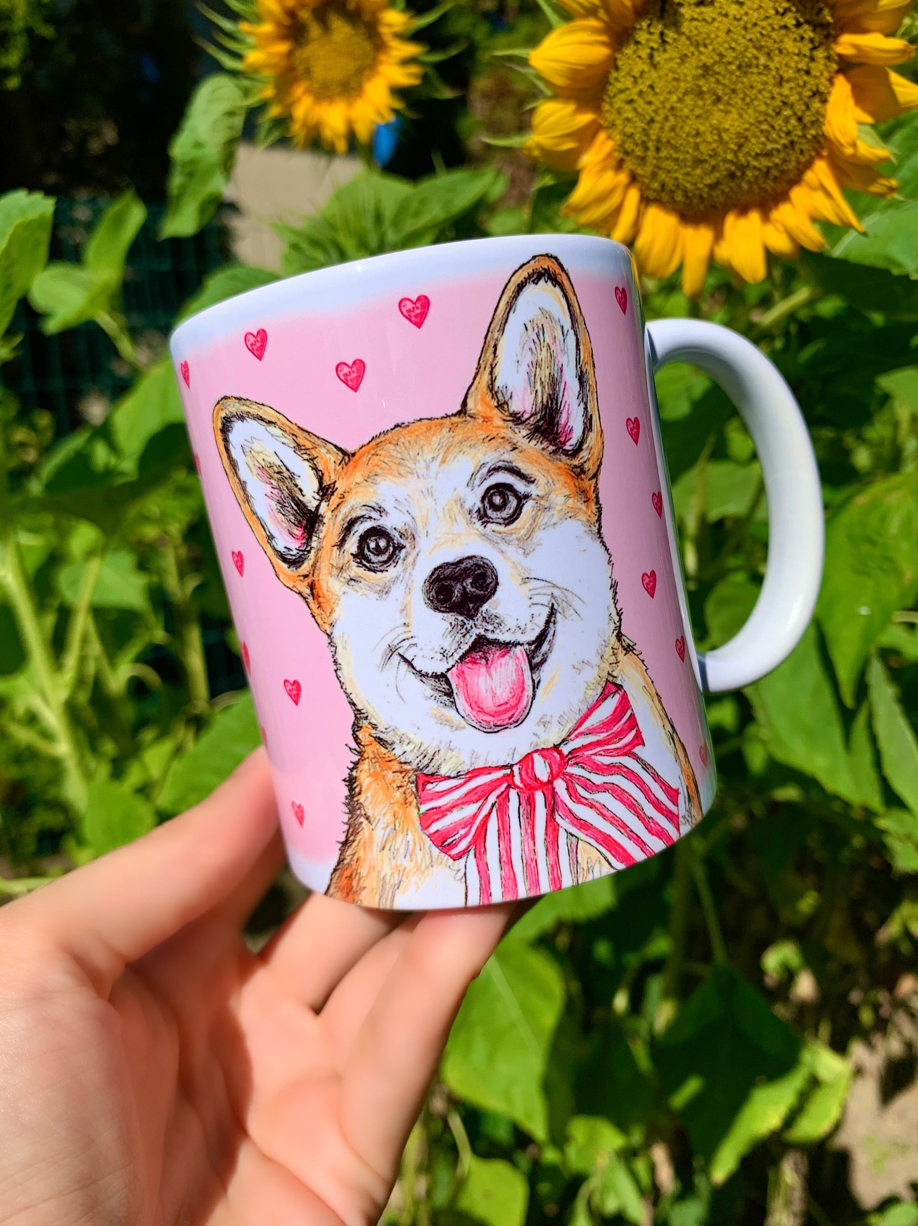 Kerámia bögre teljes alakos világosbarna-fehér Corgi kutya illusztrációval, rózsaszín szív mintákkal, részletes akvarell grafikával, fehér háttérrel.