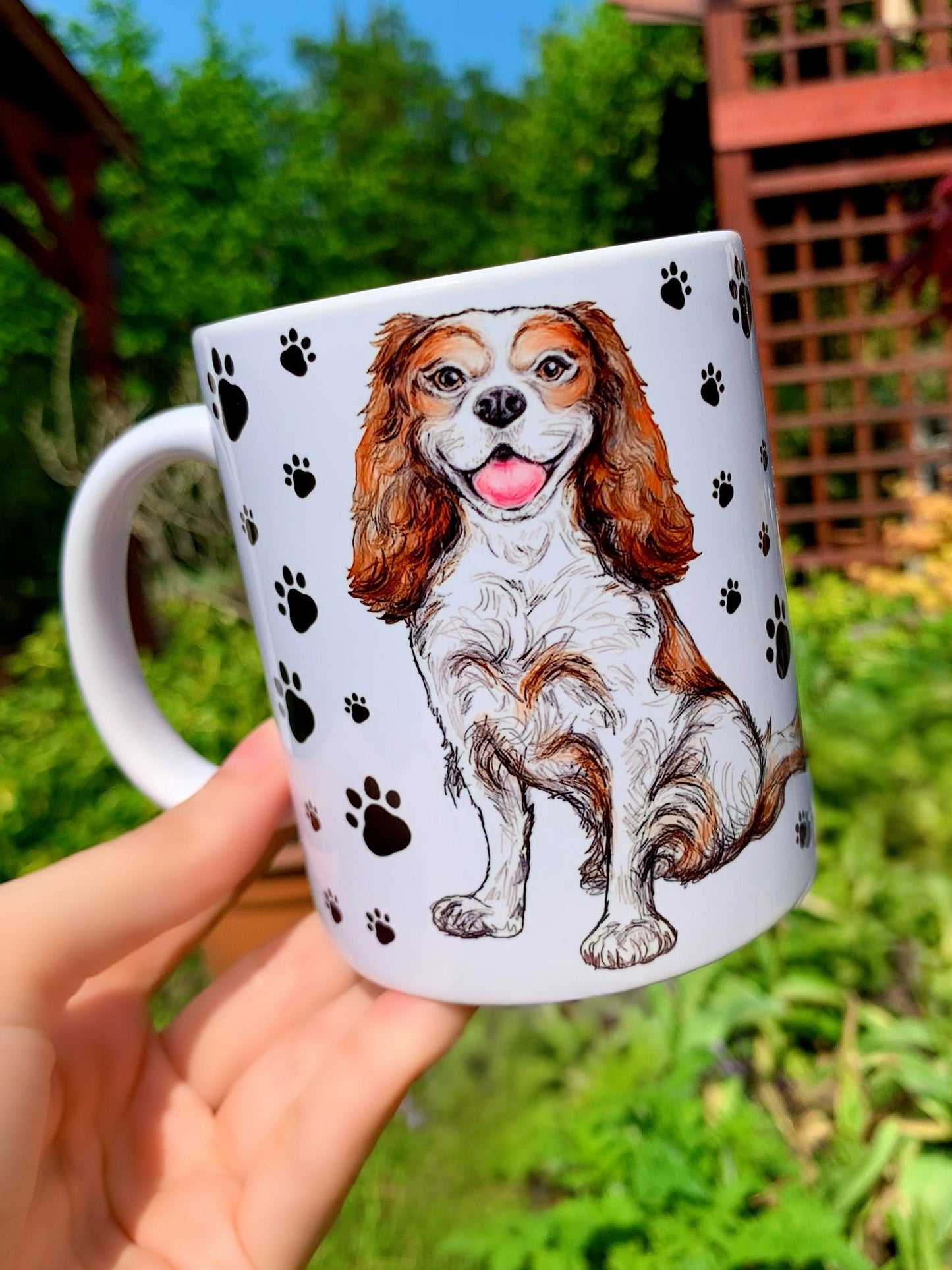 Vidám Cavalier spániel illusztrációval díszített kerámia bögre, fekete mancsos mintával