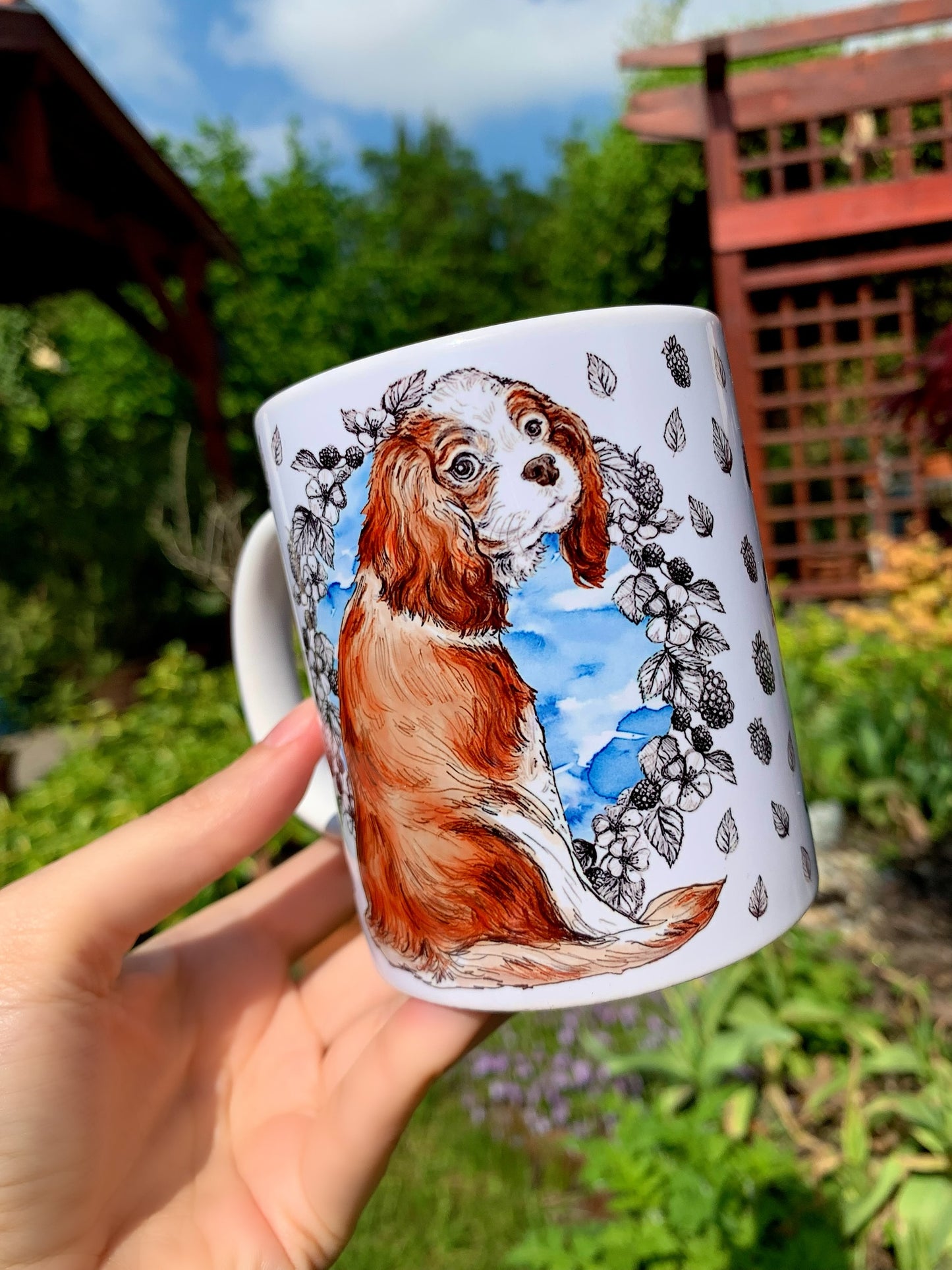 Ajándék kerámia bögre kézzel festett Cavalier spániel mintával, kék akvarelles háttérrel és rajzos gyümölcsös-leveles díszítéssel
