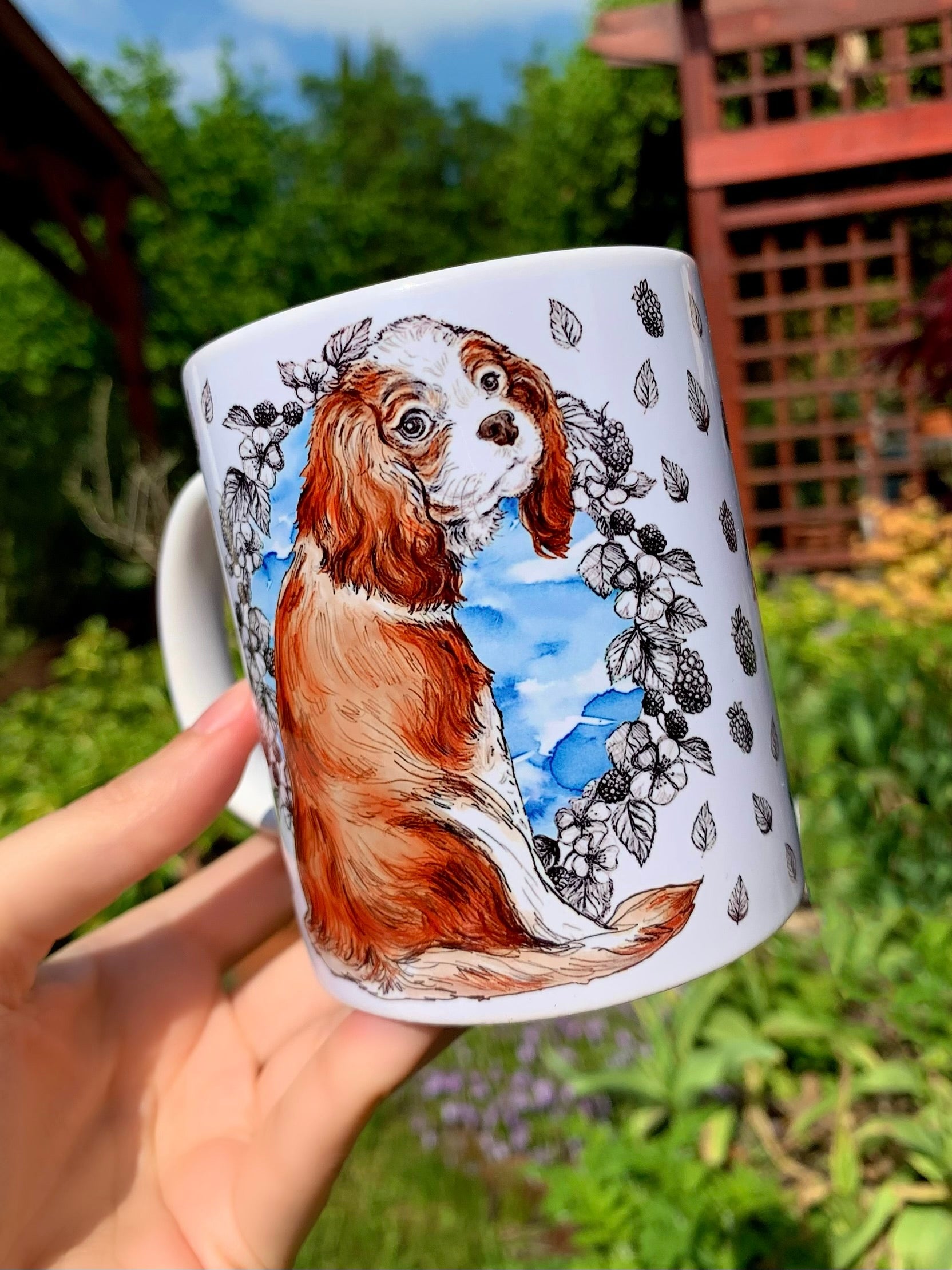 Egyedi Cavalier spániel kutyás kerámia bögre, kézzel rajzolt gyümölcs- és levélmintákkal, kék akvarell középrésszel kiemelve