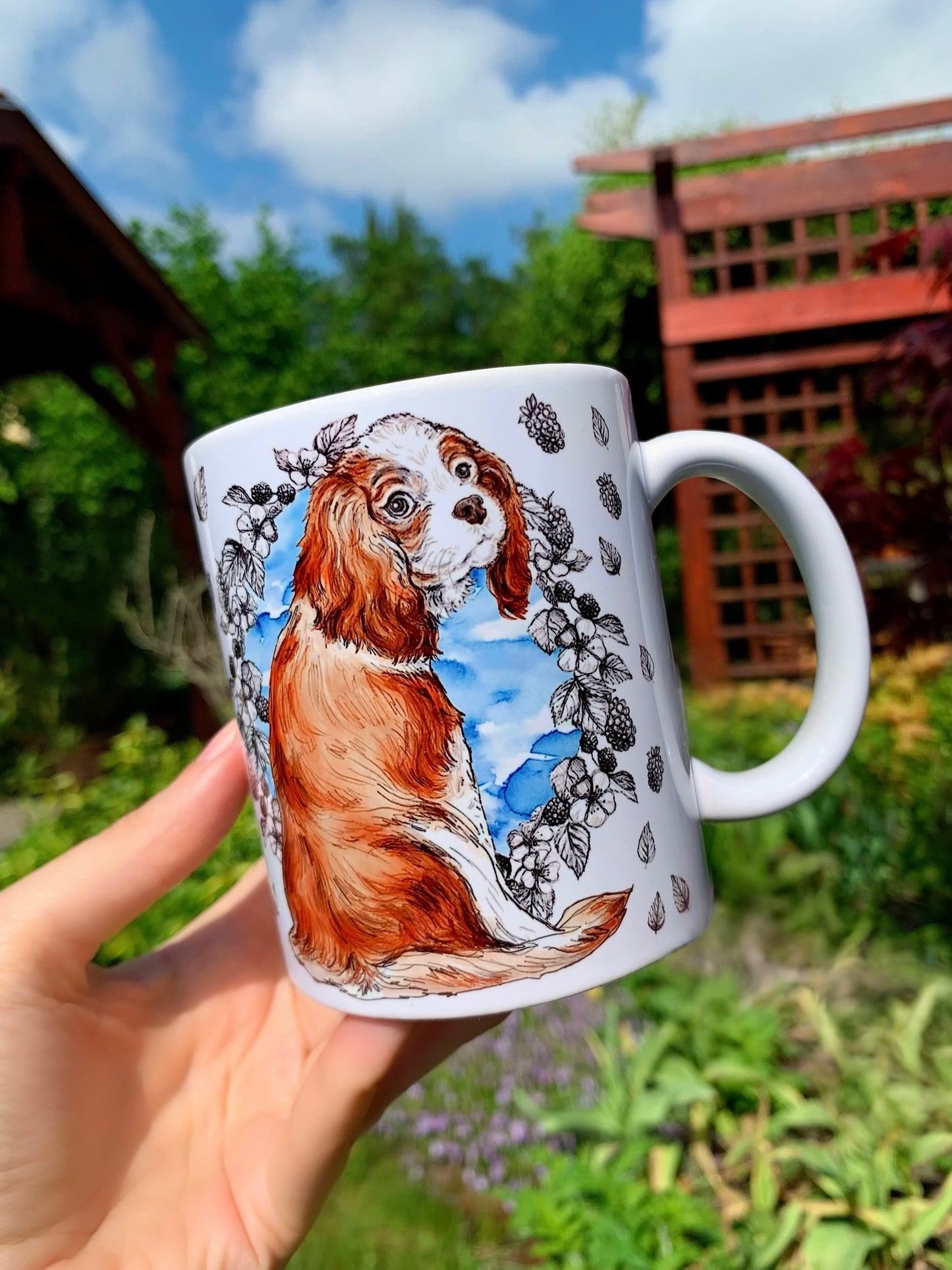 Akvarell technikával festett Cavalier spániel kerámia bögre, kék középrésszel, rajzos levelek és gyümölcsök mintájával