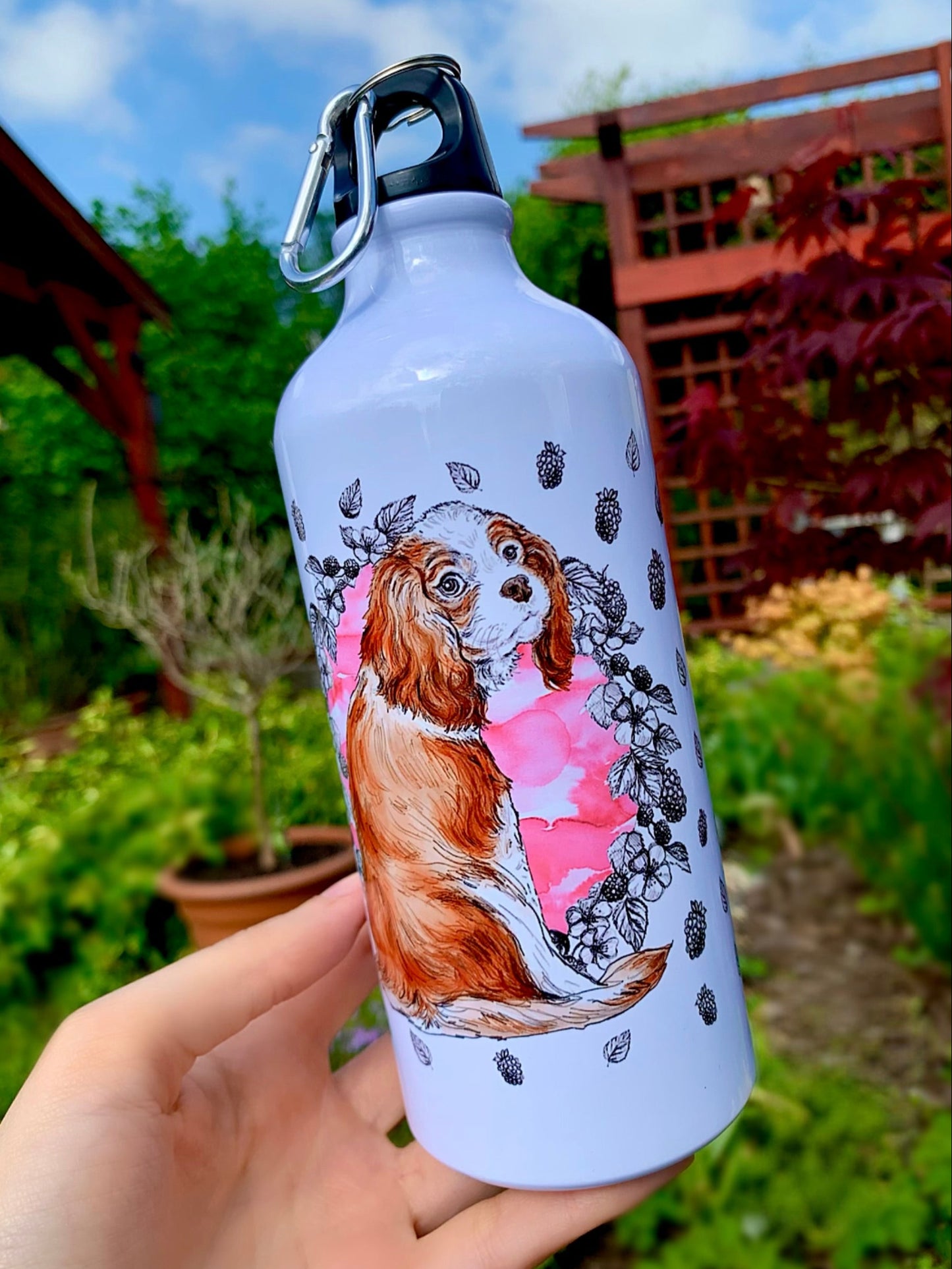Kedvesen néző Cavalier spániel akvarell festett portré fém kulacson, rózsaszín gyümölcsös és leveles kézzel rajzolt mintával