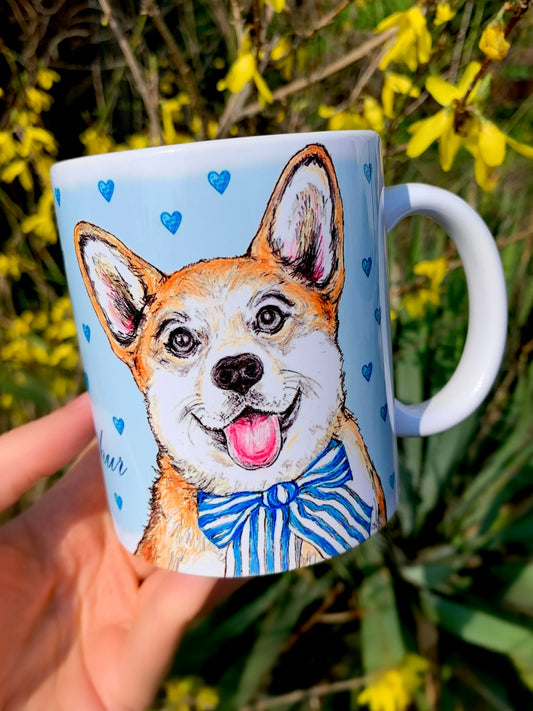 Kerámia bögre kézzel festett világosbarna-fehér Corgi kutyával és világoskék szív mintákkal, mosolygó kutyával, fehér háttérrel, részletgazdag grafikával. Prémium ajándék gazdiknak, kutyabarátoknak.