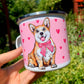Fém bögre nagyított, kézzel festett világosbarna-fehér Corgi arcképpel, mosolygó tekintettel és rózsaszín szív mintákkal, fehér háttérrel.