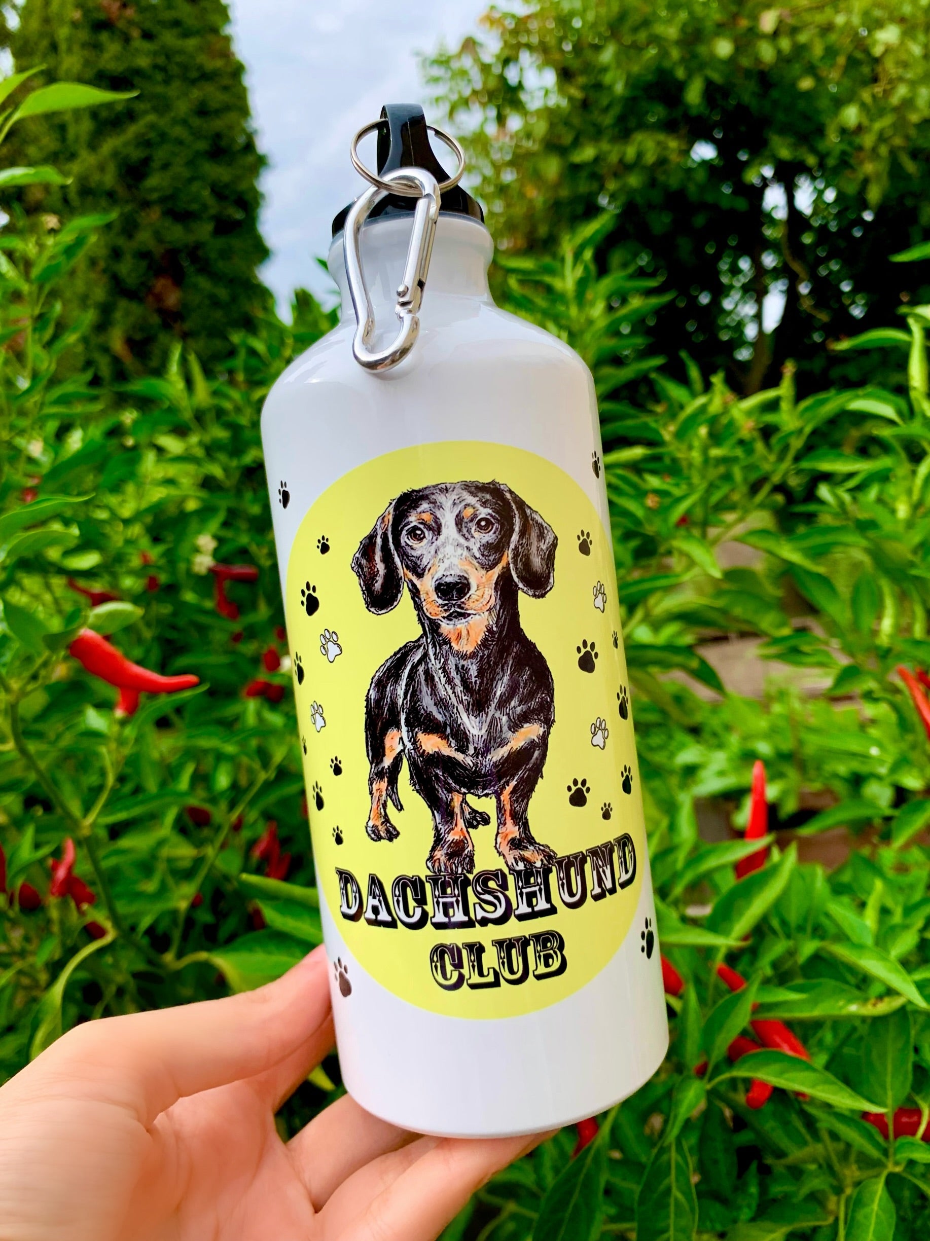 A kulacson megjelenő cser tacskó részletgazdag, kézzel festett stílusban készült, amelyet egy különleges, pasztell színes háttér egészít ki. A fém kivitel tartósságot ad, így mindennapi használatra is tökéletes. Ajándéknak is kiváló választás, ha egy valóban egyedi kutyás kulacsot keresel.