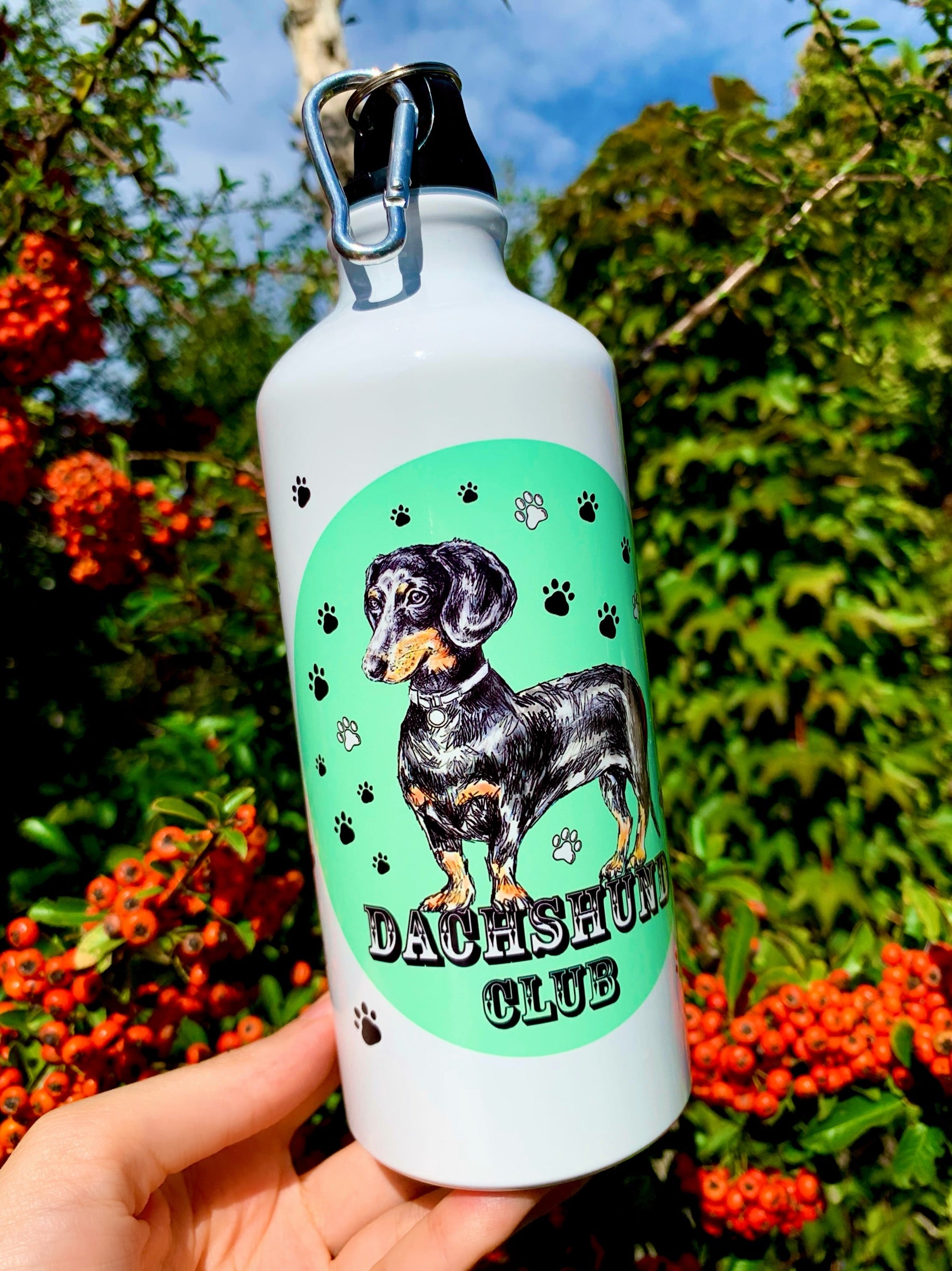 Ez a tacskós kulacs gyönyörű, kézzel festett cser tacskó illusztrációval és egyedi színes háttérmintával készült, amely modern és művészi hatást ad a fém palacknak. A 600 ml-es űrtartalom ideális egész napos használathoz, akár munkába, akár sétákhoz. Tökéletes ajándék tacskó gazdiknak, akik szeretik az egyedi, kutyás kiegészítőket.