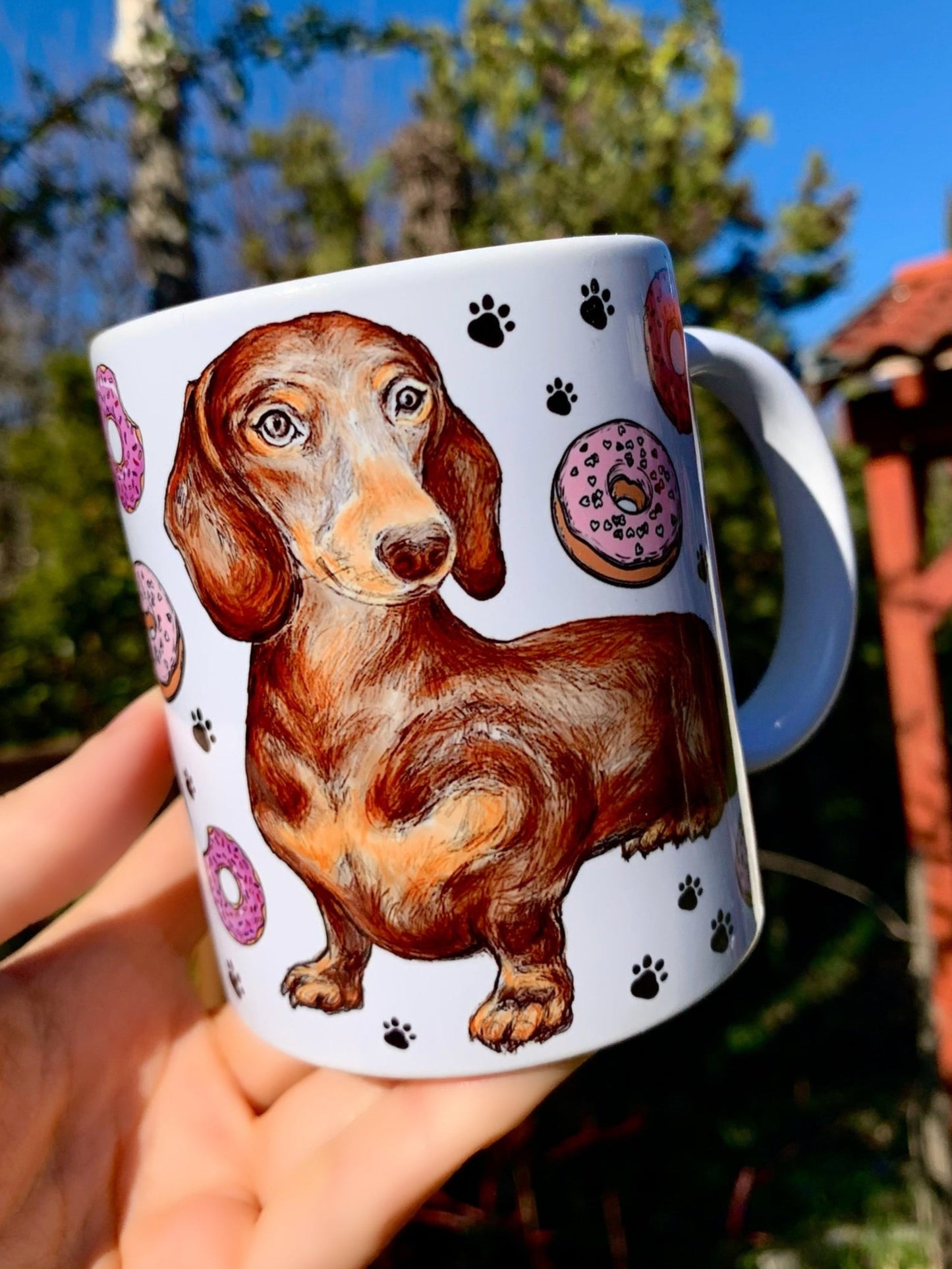 Kézzel rajzolt és festett csokibarna tacskó, színes süteményekkel és fekete mancs mintákkal – exkluzív kerámia bögre ajándéknak. Tökéletes kutyás ajándék!