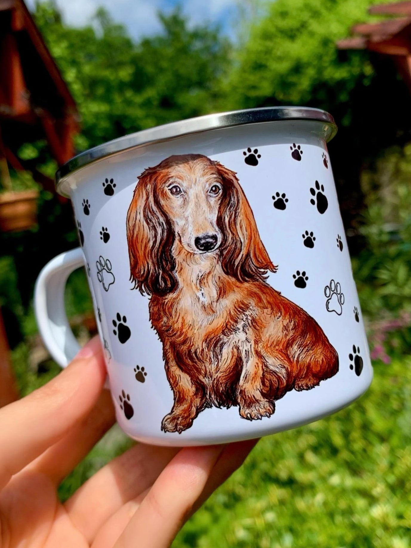 Kézzel festett hosszúszőrű tacskó portré fekete mancsnyomokkal díszített prémium fém bögrén, selymes barna szőrárnyalatokkal.