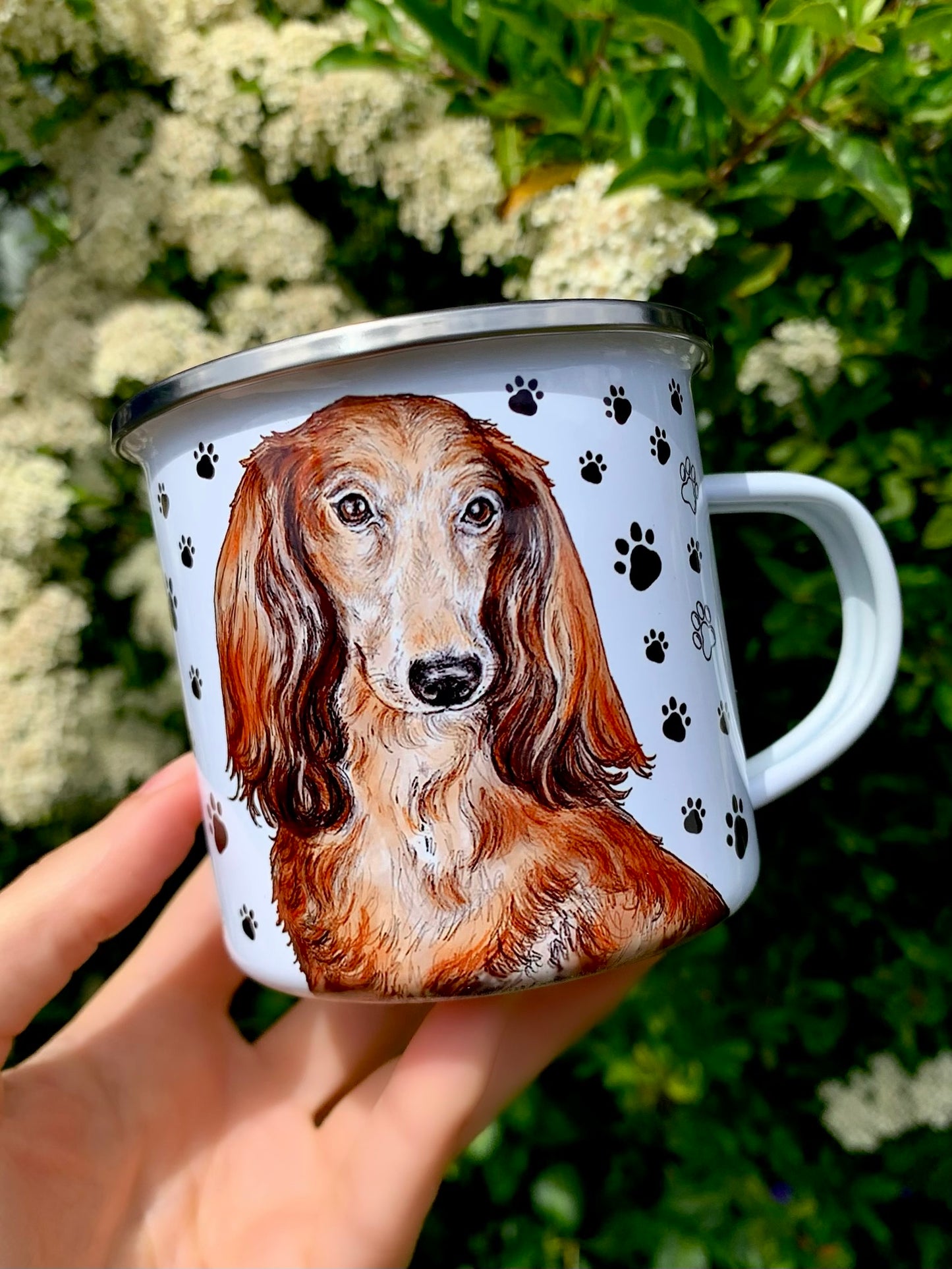 Selymes szőrű hosszúszőrű tacskót ábrázoló kézzel festett fém bögre fekete mancsnyomos dekorral, mindennapi használatra.