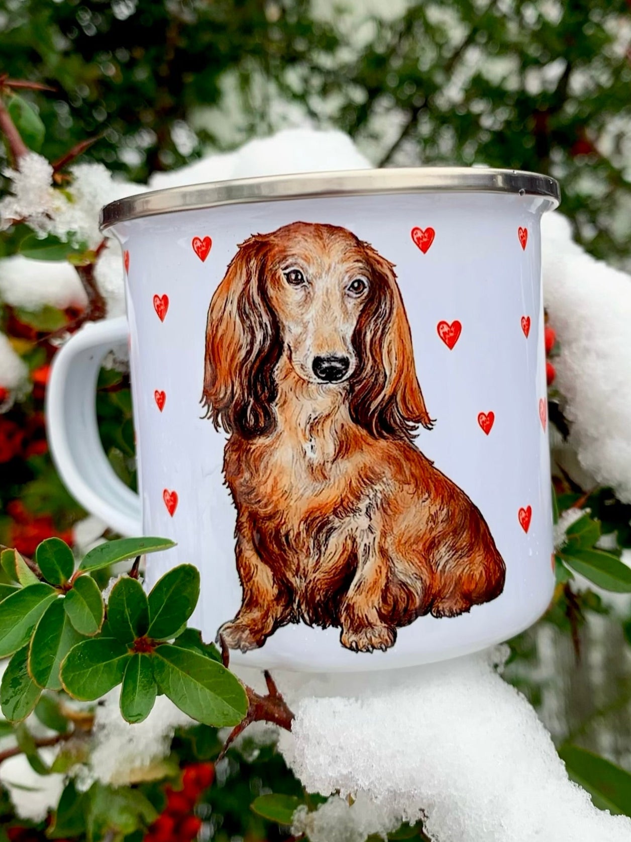 Prémium minőségű fém bögre, hosszúszőrű tacskó kézzel festett portréjával és szeretetteljes piros szív mintákkal díszítve.