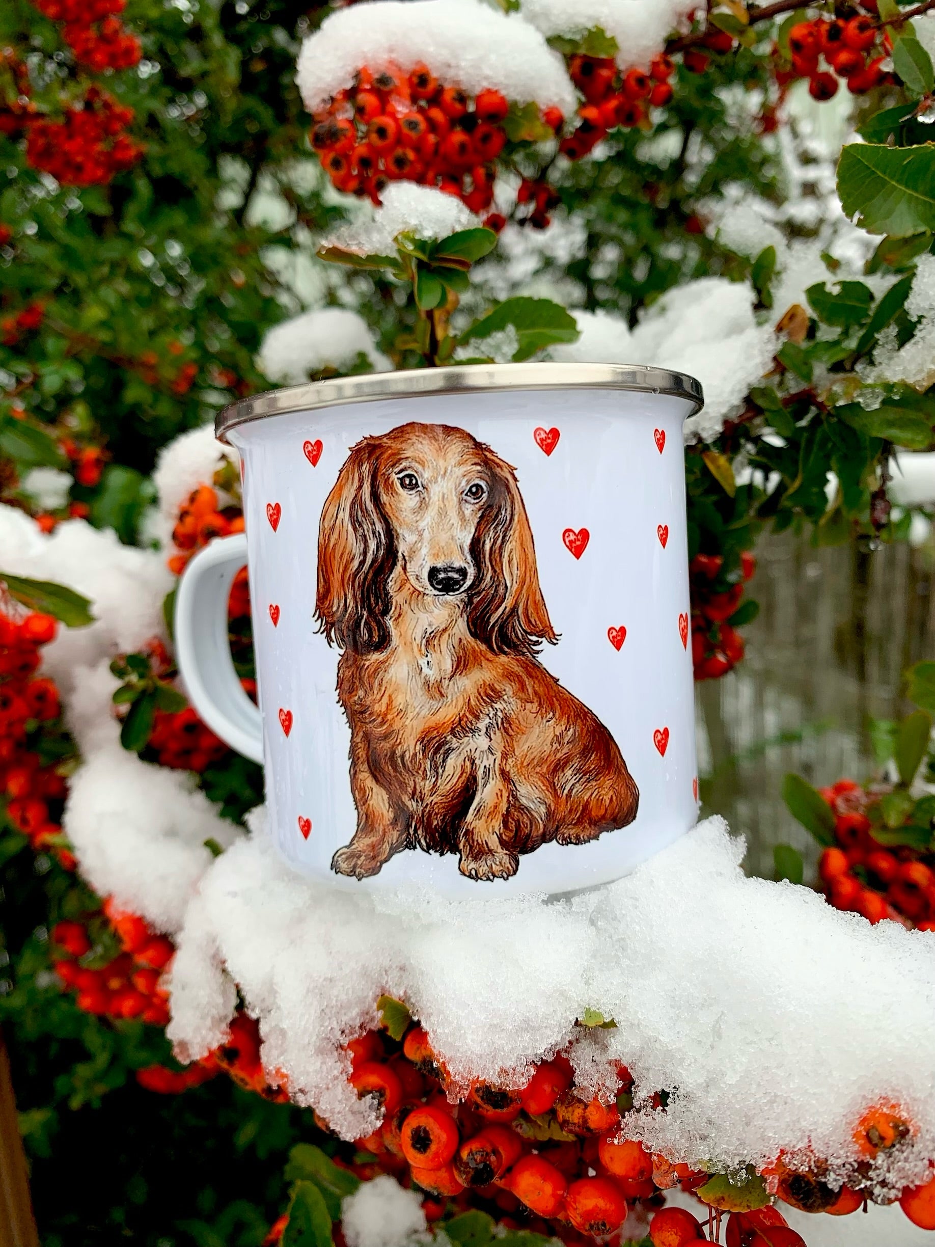 Könnyű, strapabíró fém bögre kézzel rajzolt és festett hosszúszőrű tacskóval, piros szív dekorral – ajándéknak is tökéletes.