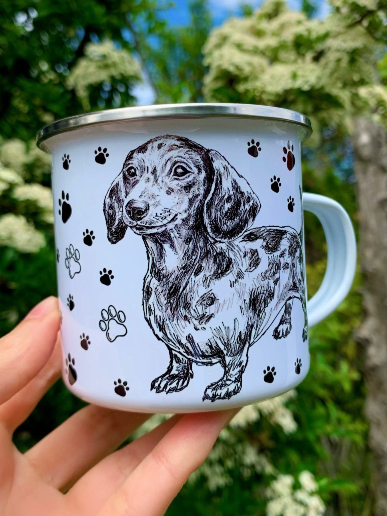 Fém bögre kézzel rajzolt grafit színű merle tacskó portréval és fekete mancsnyomokkal, elegáns, részletgazdag kutyás dizájnnal.