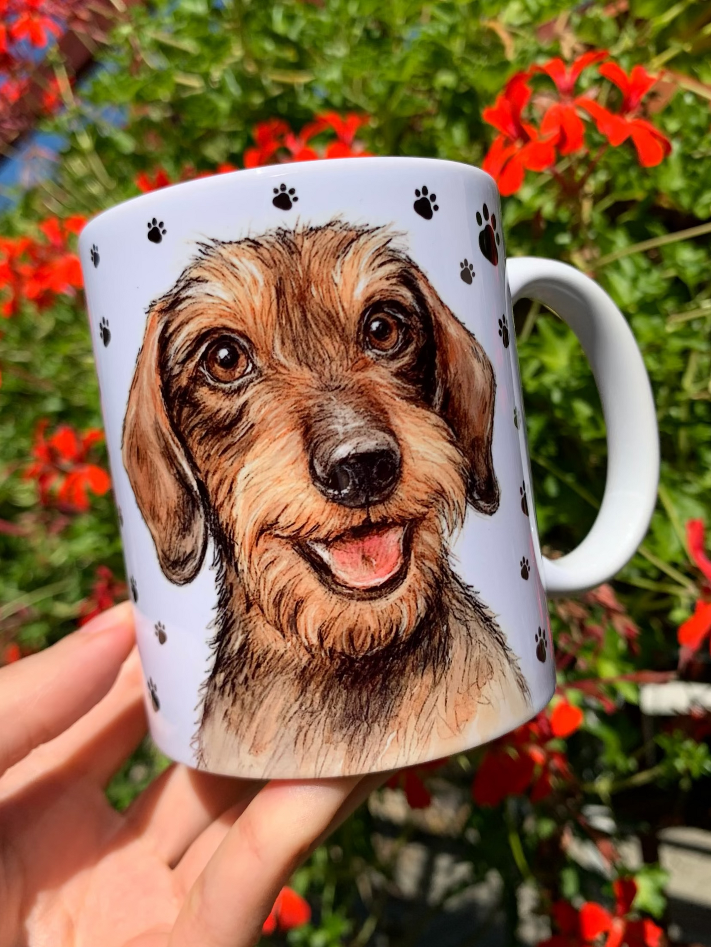 Kézzel festett szálkásszőrű tacskós kerámia bögre, részletgazdag portréval és teljes alakos kutyaillusztrációval, fehér alapon fekete mancsnyom mintákkal.